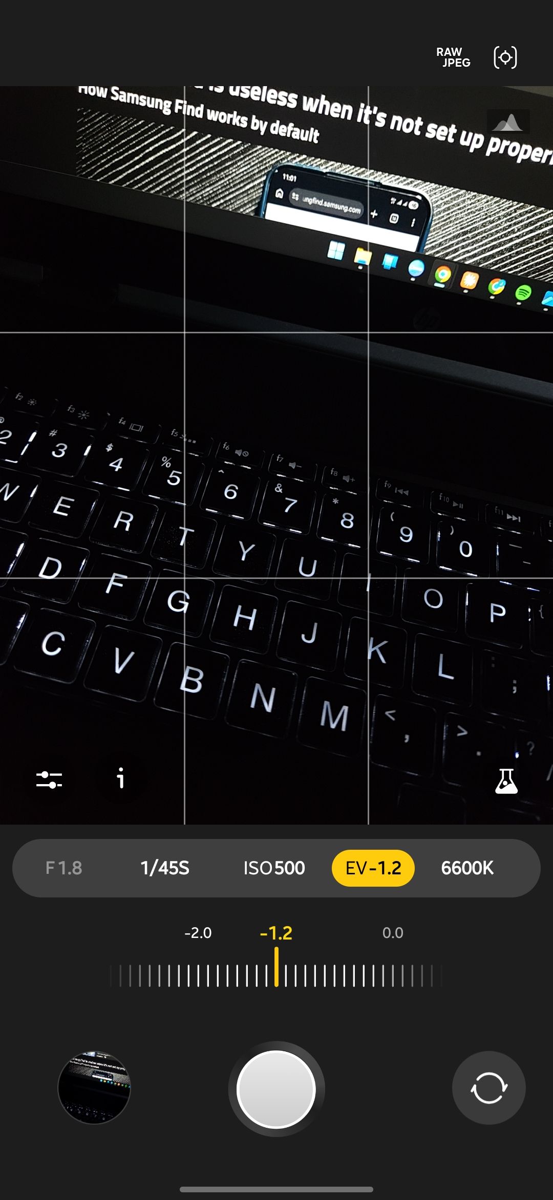 Expert RAW camera app with the exposure value slider open and set to minus 1.2 between minus 2.0 and 0.0 over a backlit laptop keyboard