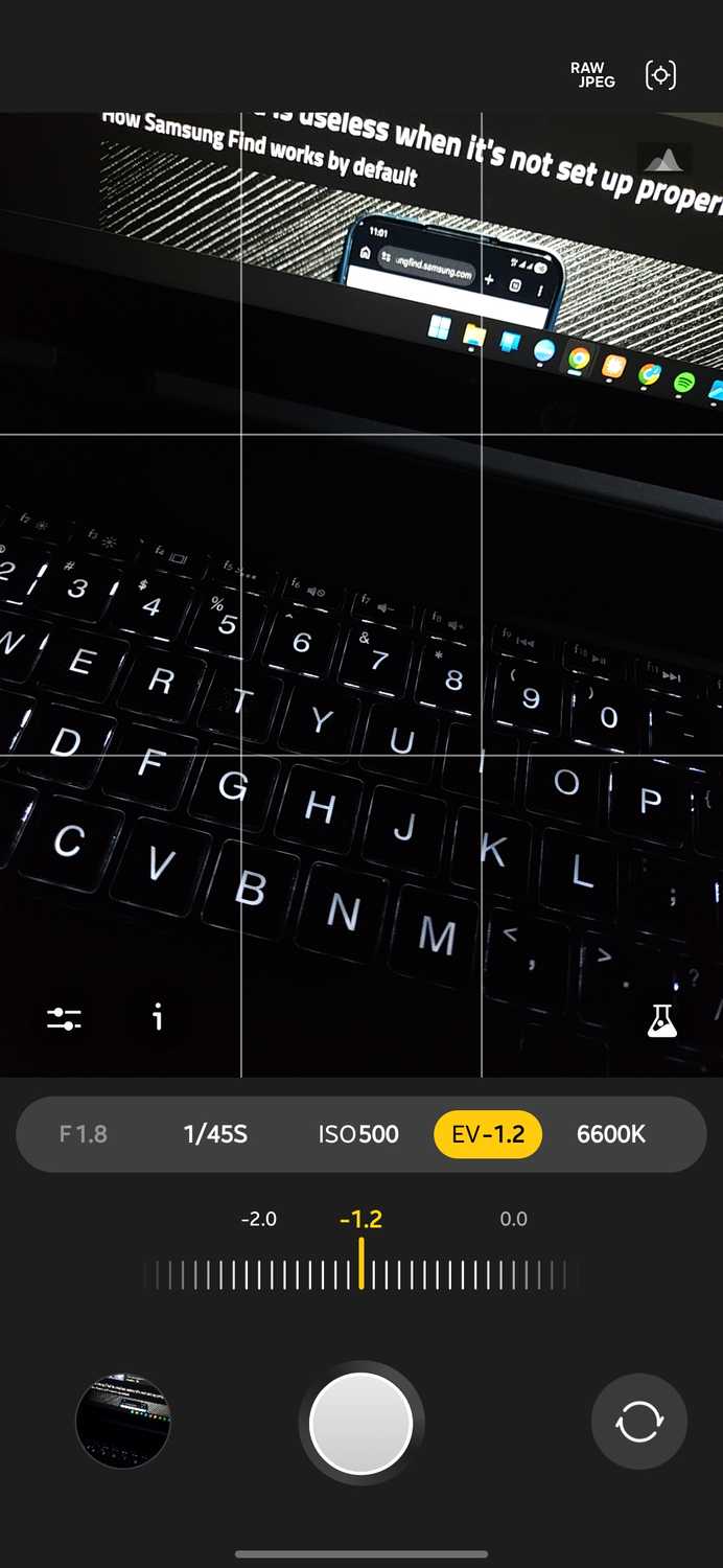 Expert RAW camera app with the exposure value slider open and set to minus 1.2 between minus 2.0 and 0.0 over a backlit laptop keyboard