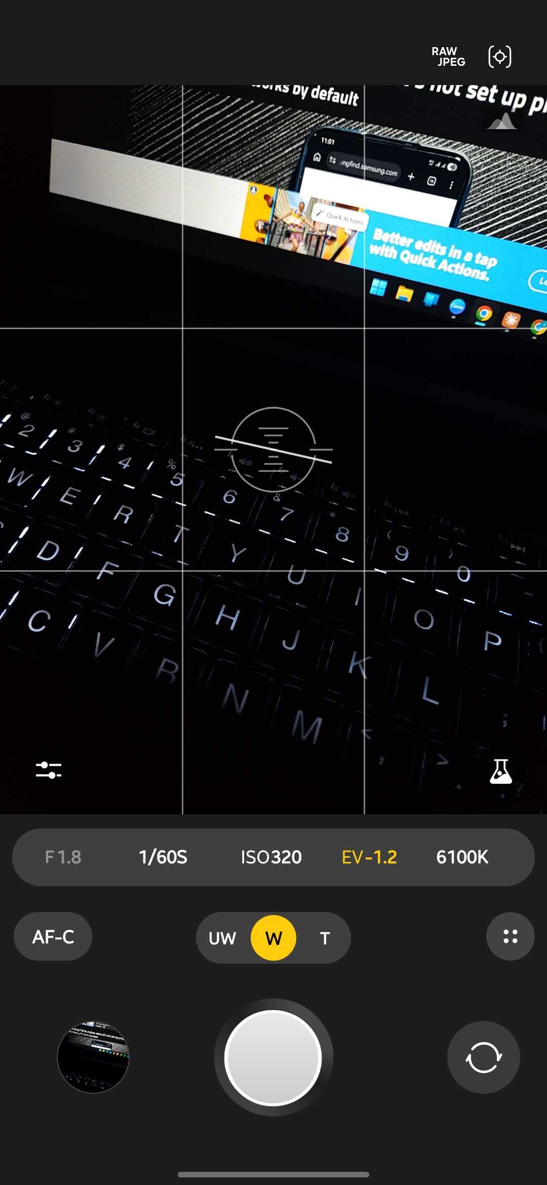 Expert RAW camera app on its main screen with the wide lens selected between the ultrawide and telephoto options, continuous autofocus on and settings of 1/60s ISO 320 and 6100K over a backlit laptop keyboard