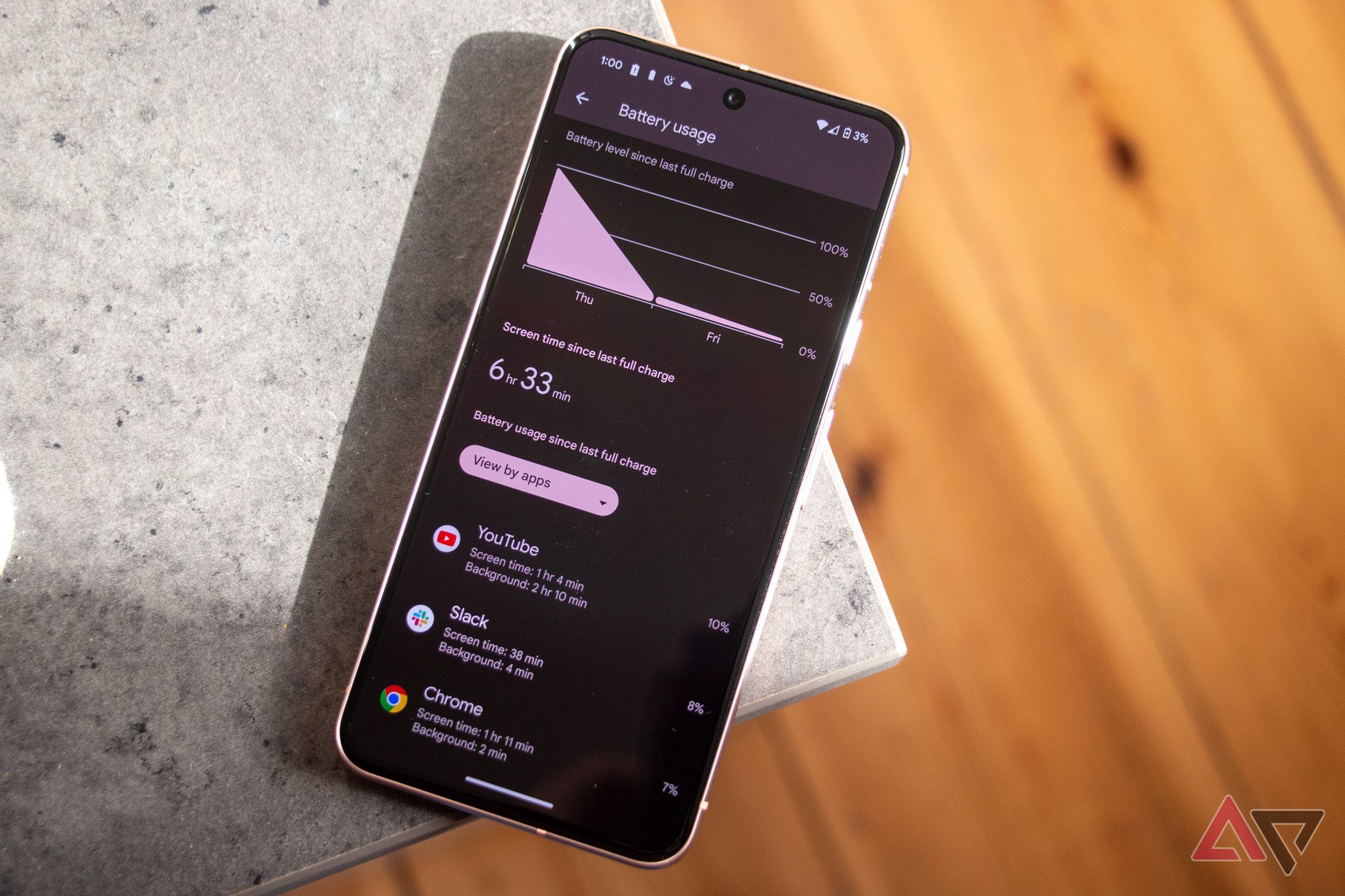 Um Pixel 8 com o app de bateria aberto apoiado na borda de uma mesa cinza