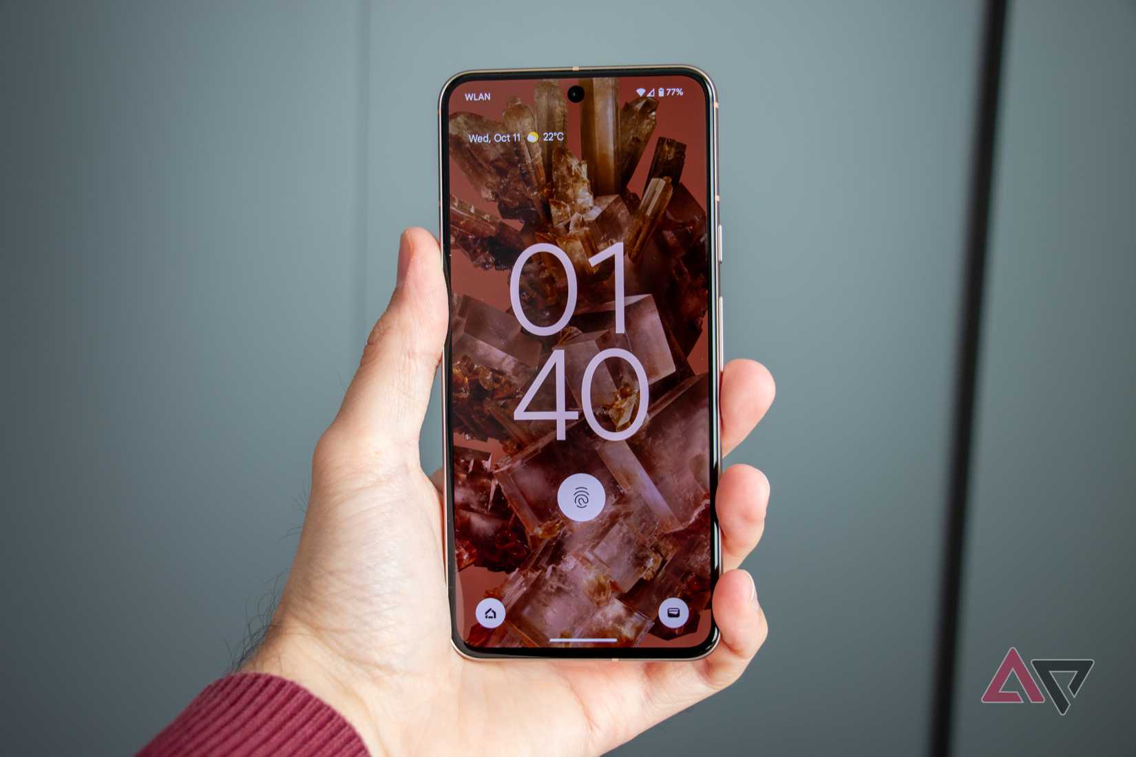 Google Pixel 8 being held up against gray background