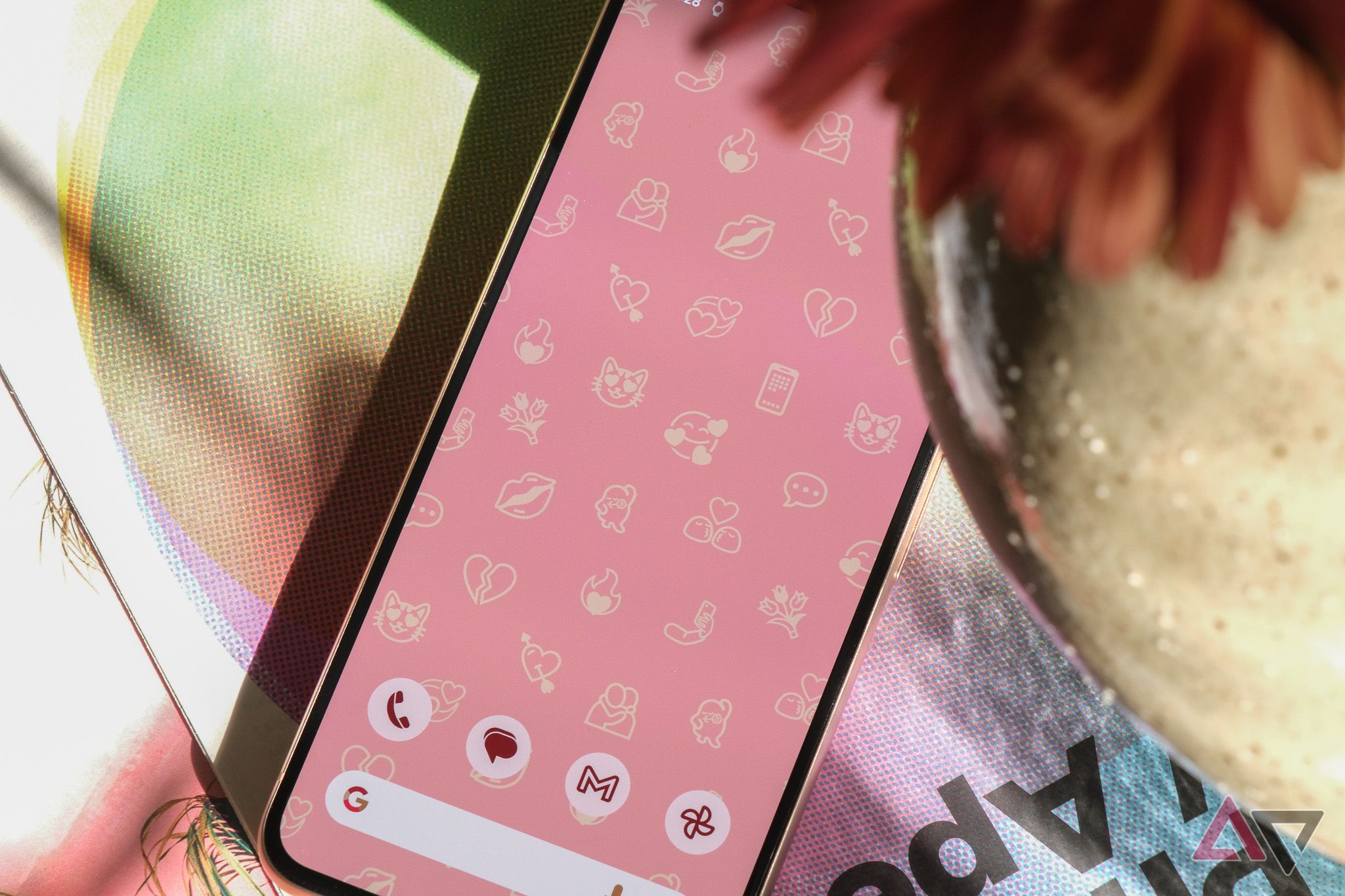 Google Pixel 8 showing emojis as a wallpaper on a pink background