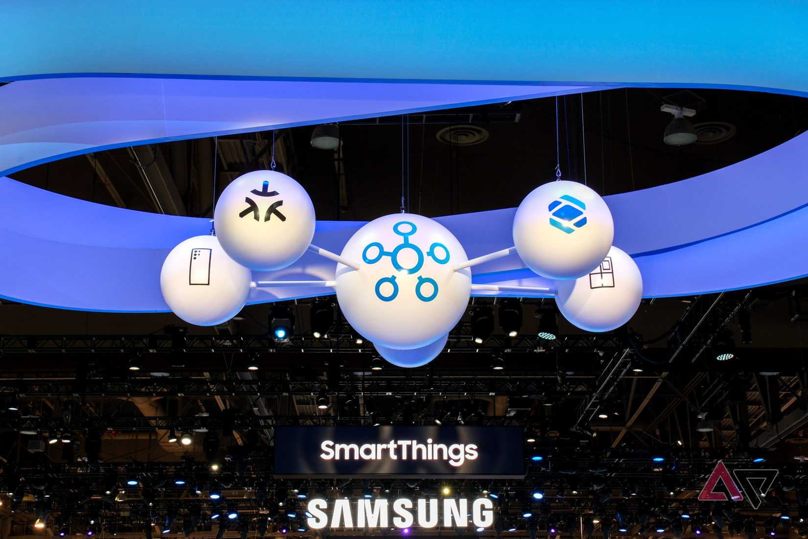 Orbs decorated with various icons hanging from the ceiling, next to signs reading 'SmartThings' and 'Samsung'