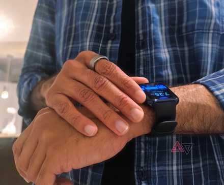 Uma pessoa usando um RingConn Smart Ring e Oppo Watch, verificando a hora
