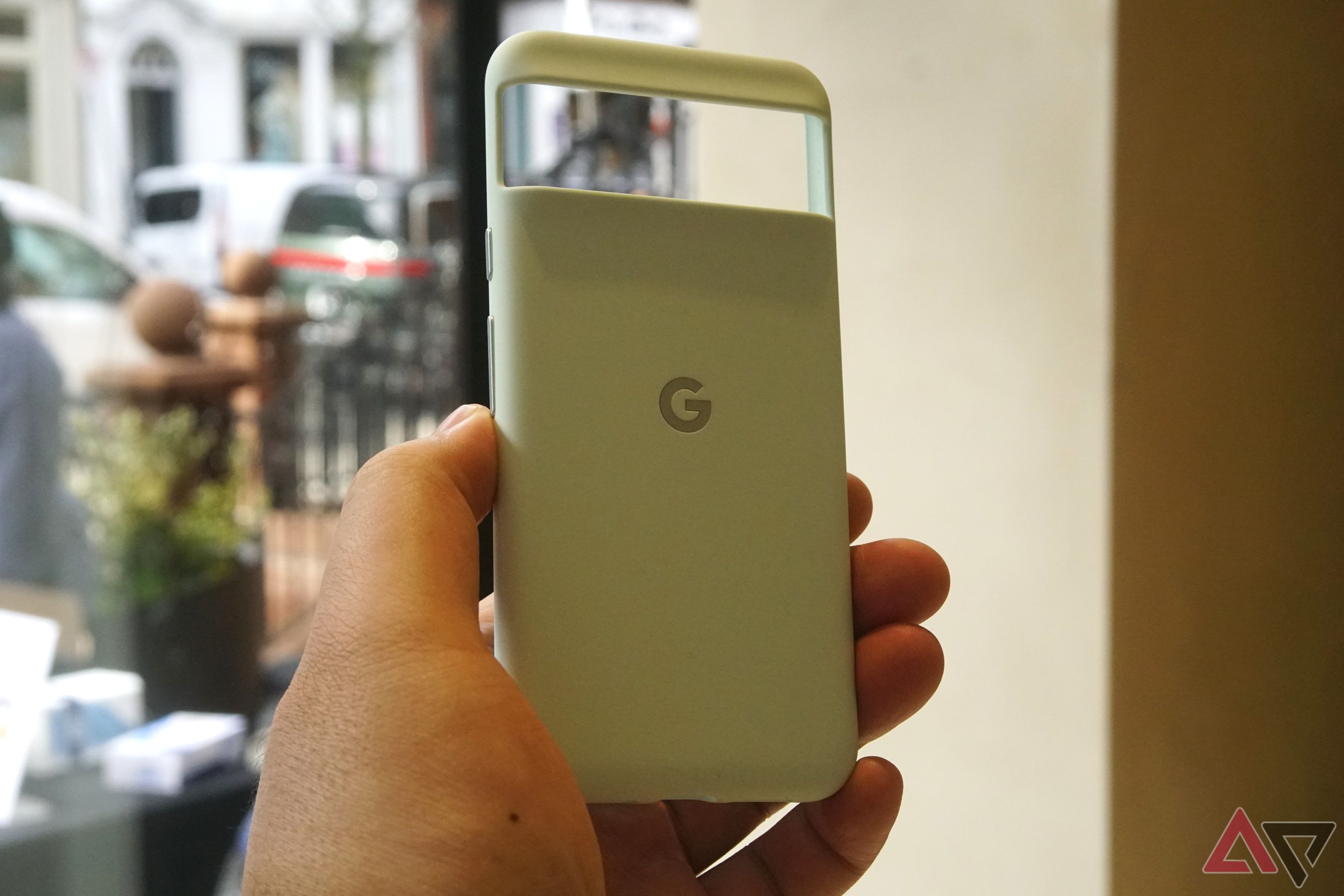 A pale green Pixel 8 Pro case held in a hand.