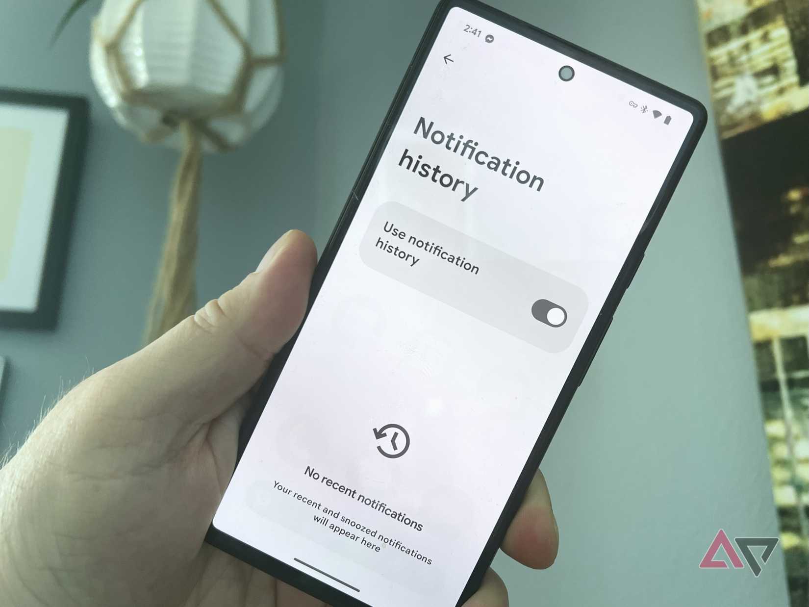Una mano che tiene un Pixel 6 con la schermata Cronologia notifiche in mostra.