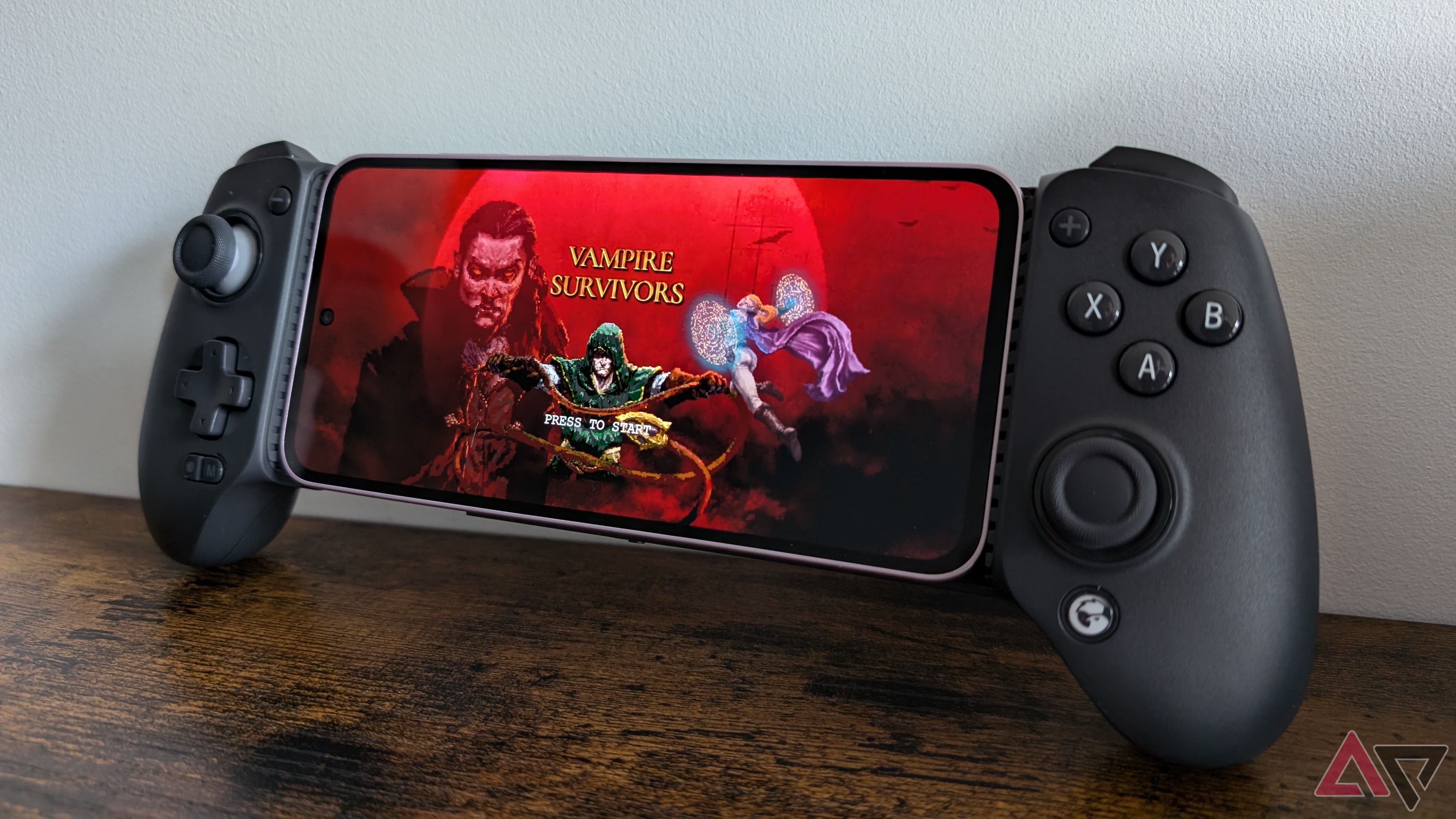 black game controller with phone showing game loading screen