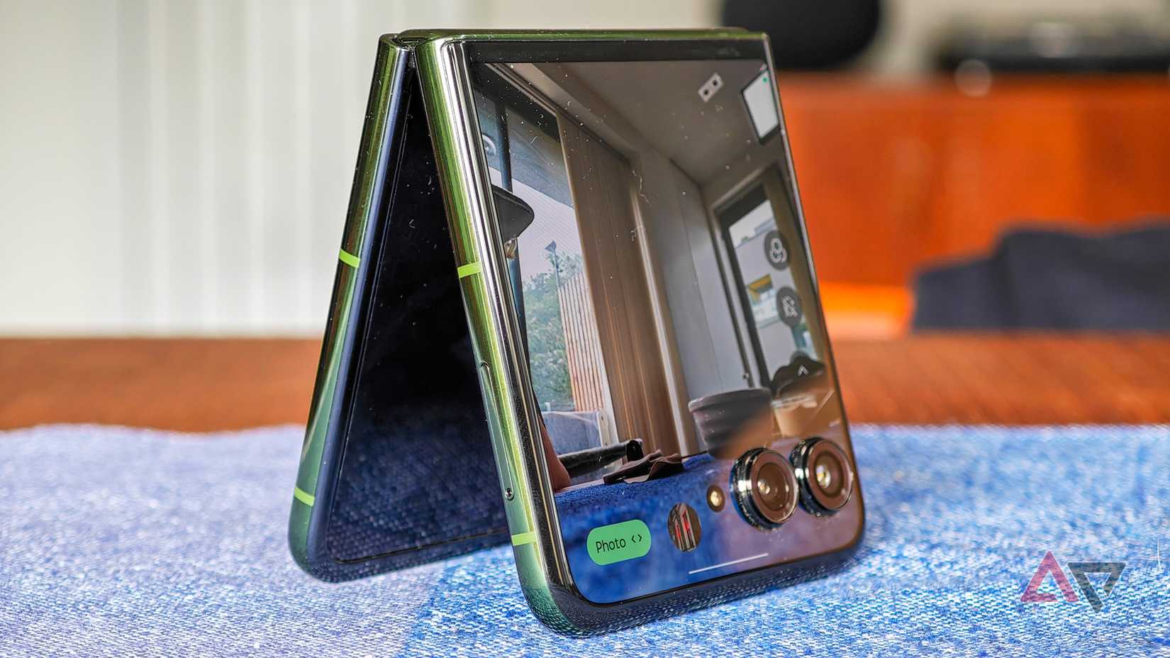 Motorola Razr+ 2024 apoiado em uma toalha de mesa azul em posição de tenda mostrando a imagem da câmera na tela externa