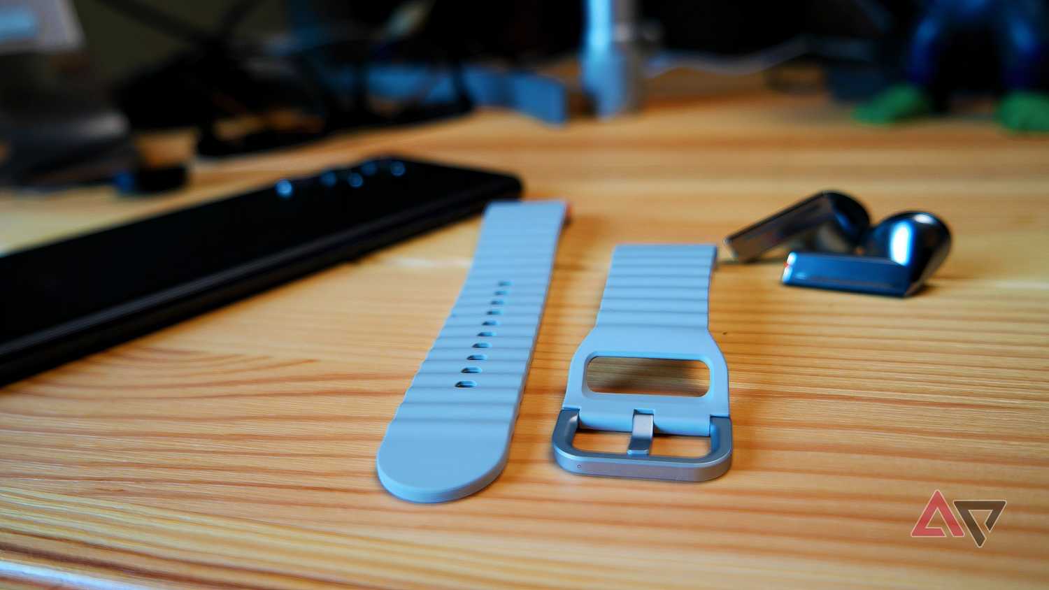Samsung Galaxy Watch 7 watch straps on a table next to Galaxy Buds 3 Pro and an S22 Ultra