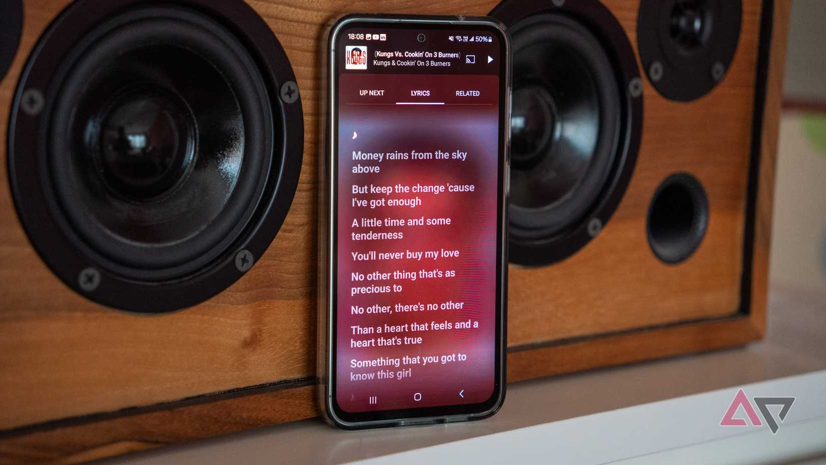 YouTube Music Premium em um telefone Samsung apoiado em um alto-falante