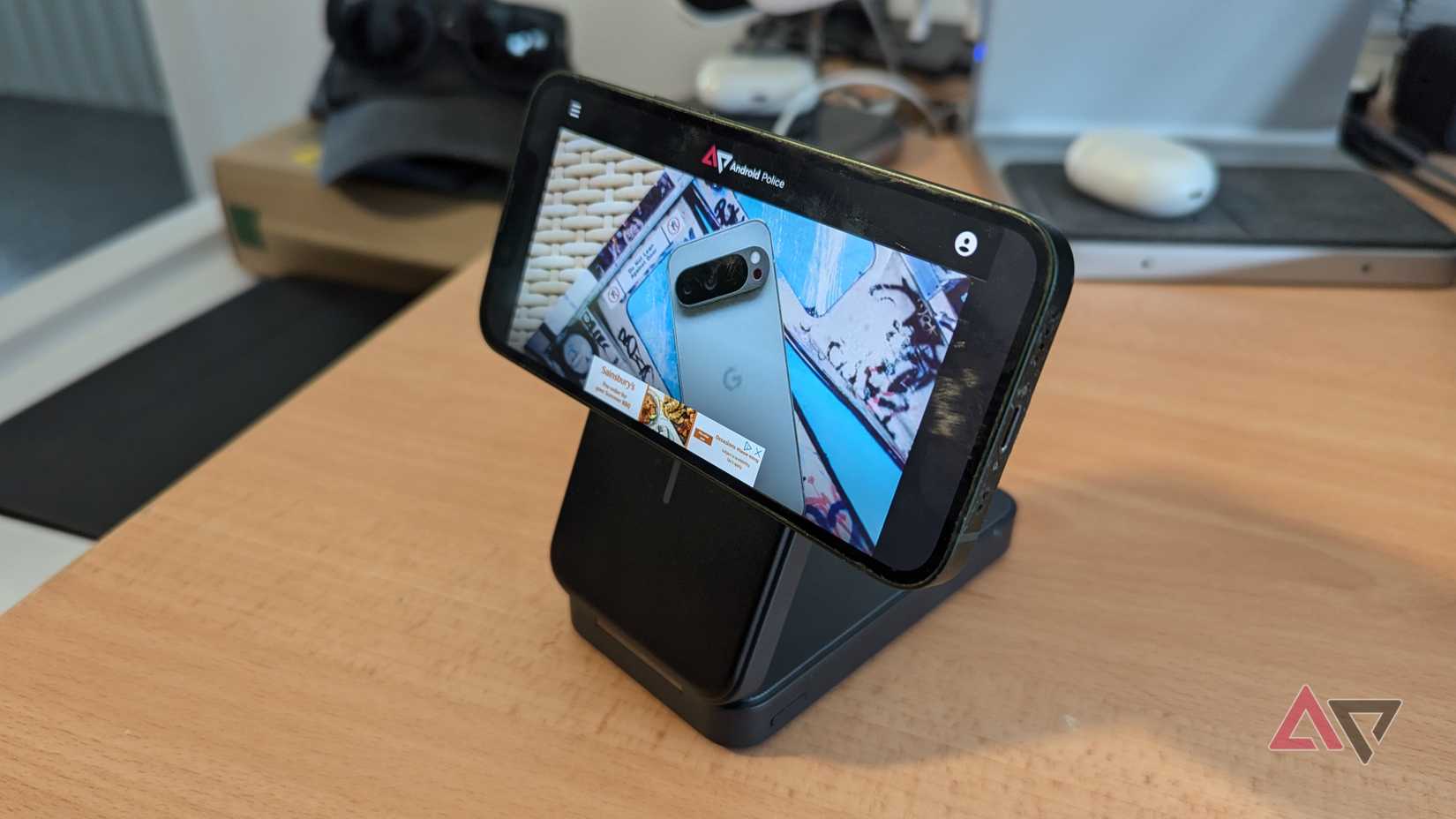 باور بانك Anker MagGo بسعة 6,600 مللي أمبير في الساعة مزود بجهاز iPhone 13 mini في وضع أفقي على المكتب