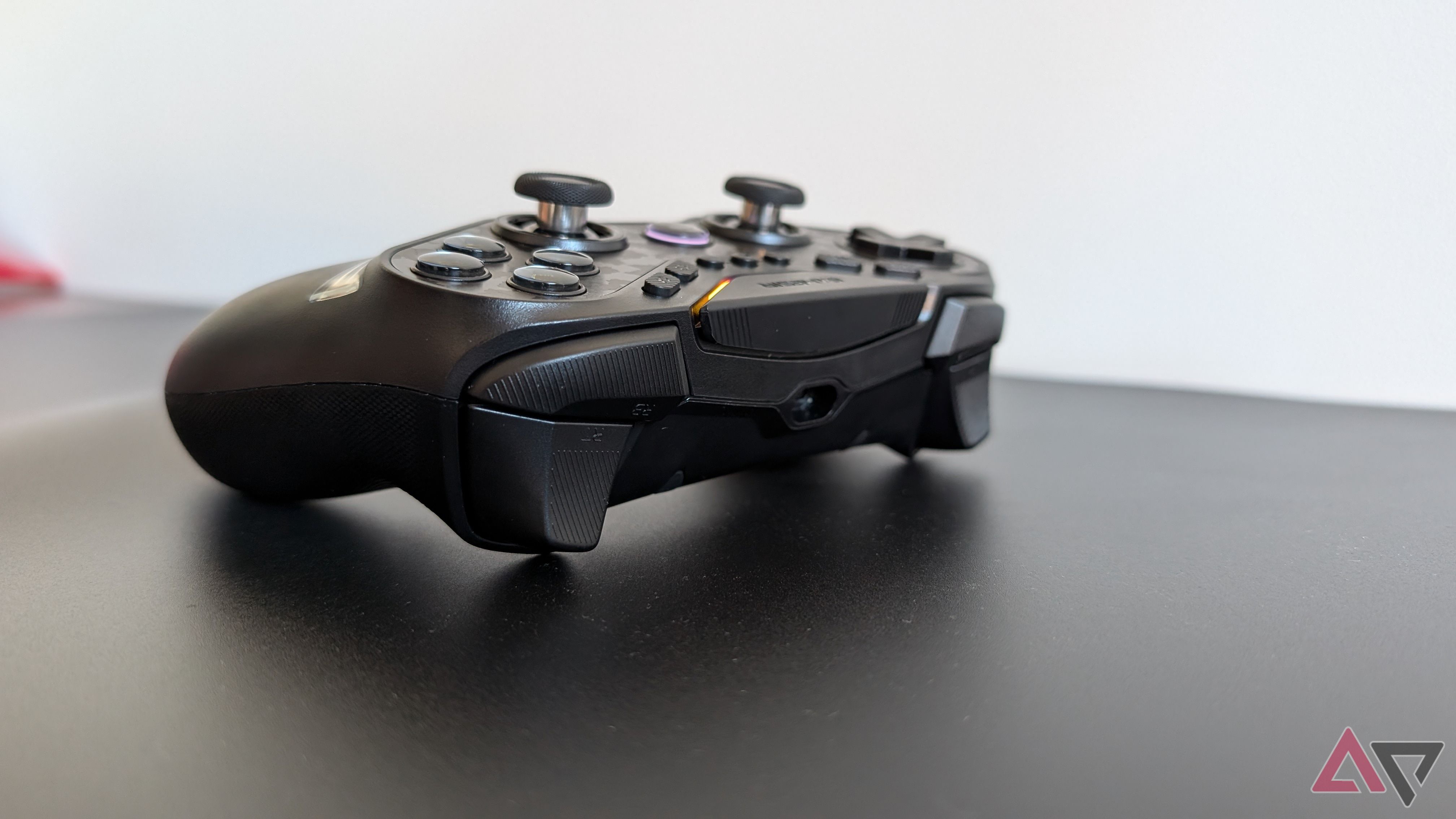 black gamesir controller resting on black surface showing bumpers and triggers