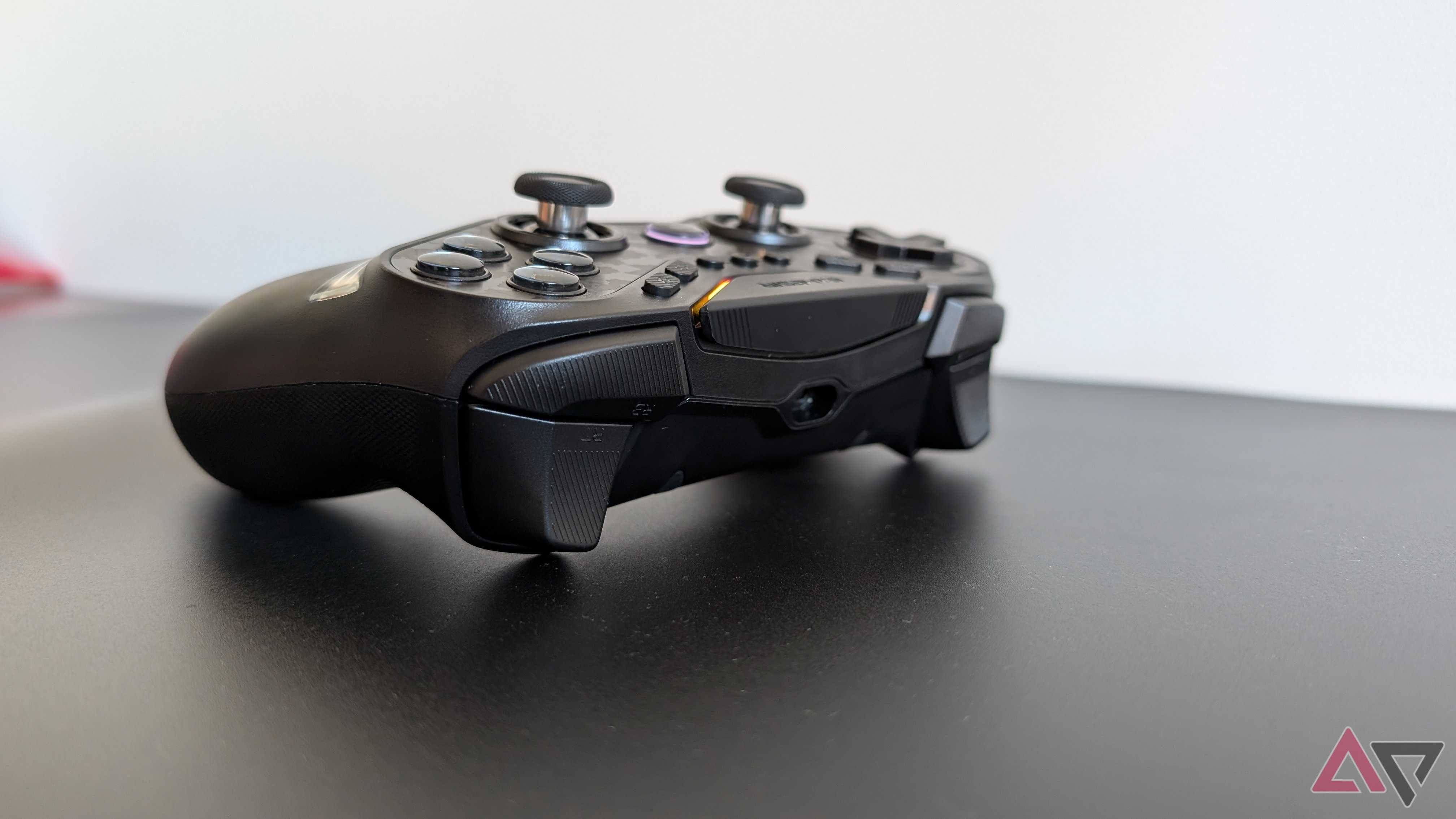 black gamesir controller resting on black surface showing bumpers and triggers