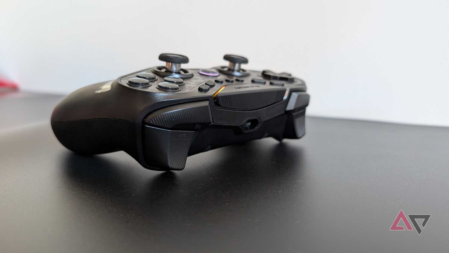 black gamesir controller resting on black surface showing bumpers and triggers