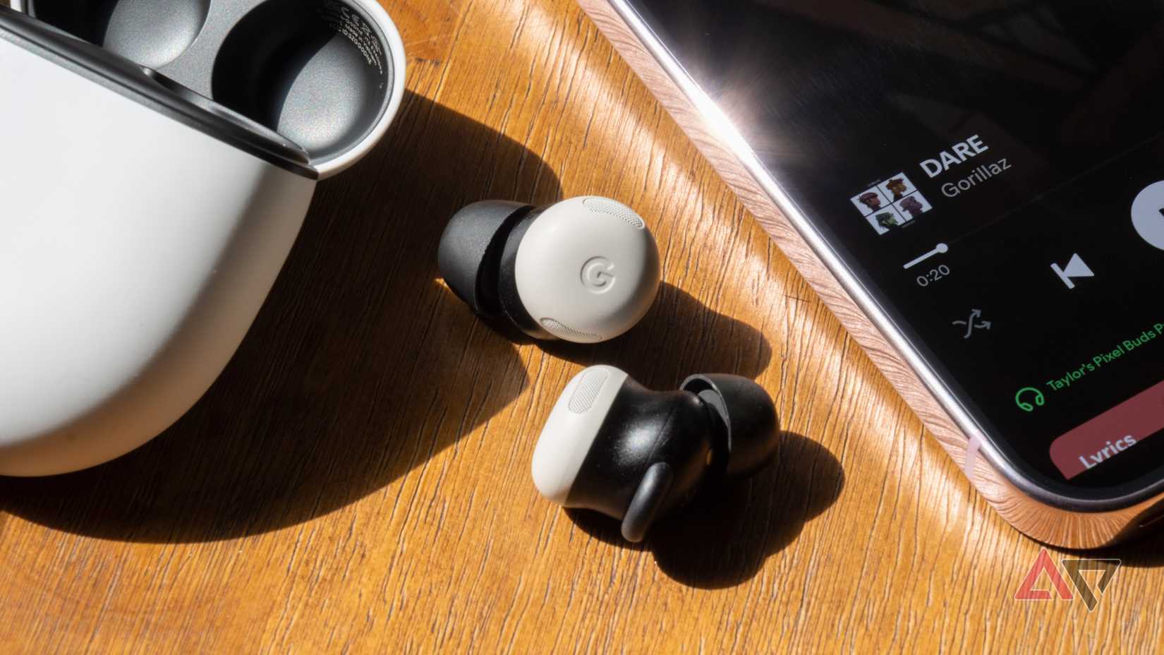 Google Pixel Buds Pro 2 next to phone with spotify on