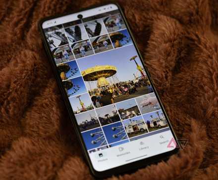 An HMD Vibe with Google Photos open laying on a brown blanket