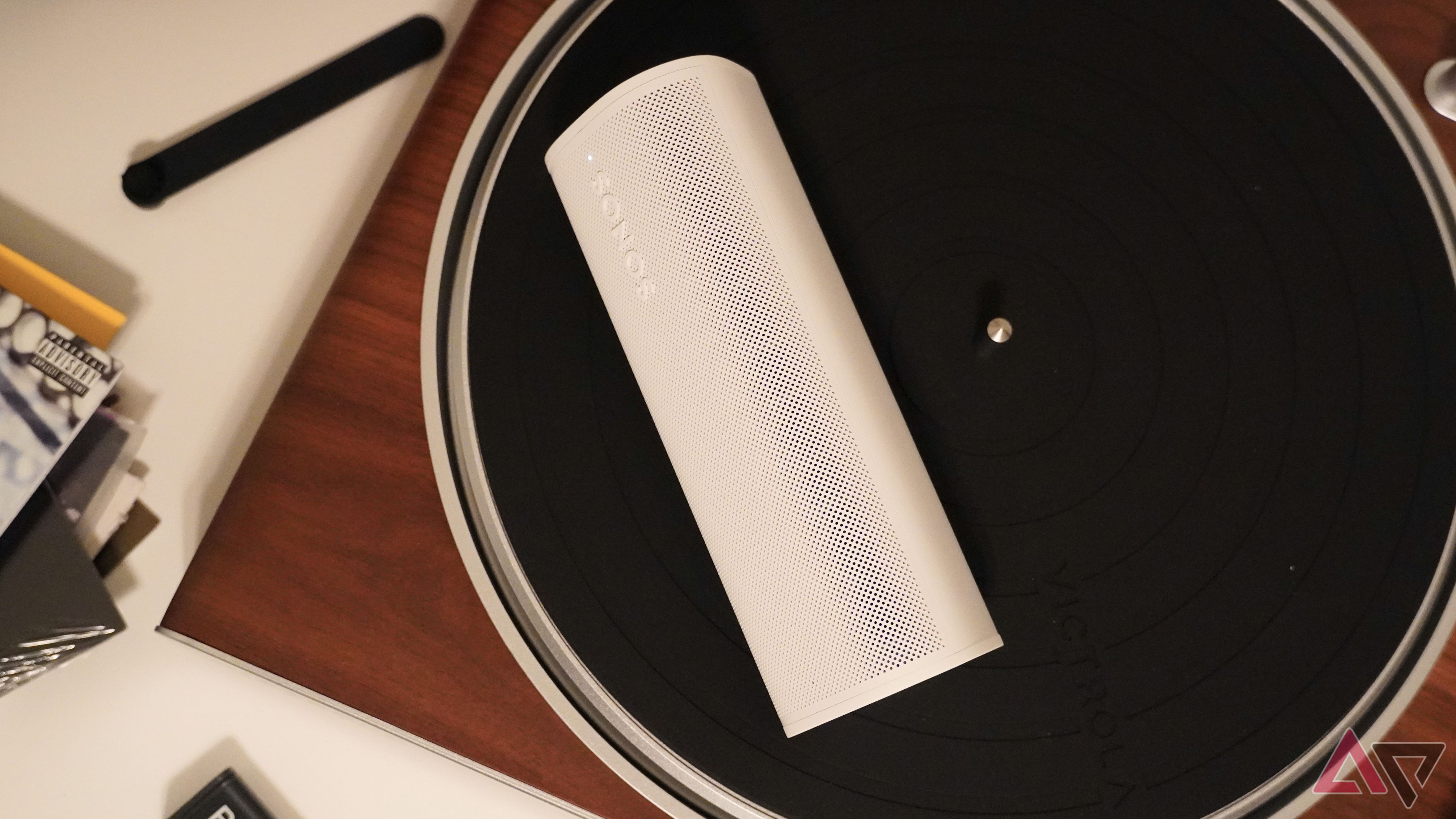 The Sonos Roam 2 on a turntable with supplies around it.