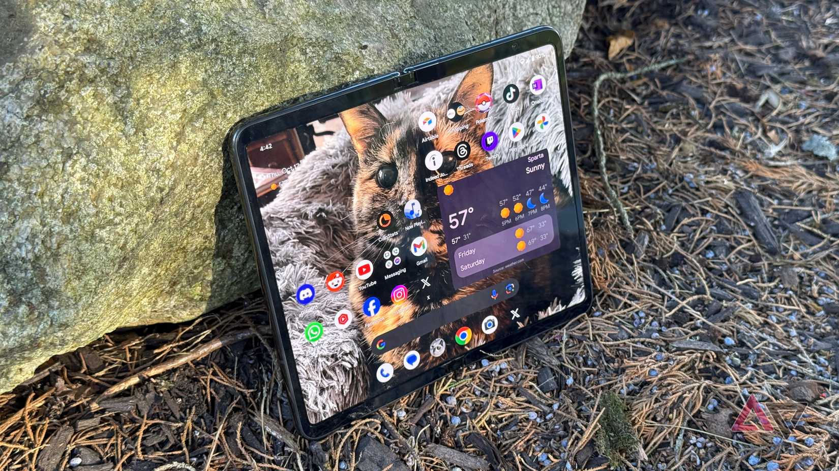 Google Pixel Fold encostado em uma pedra ao ar livre