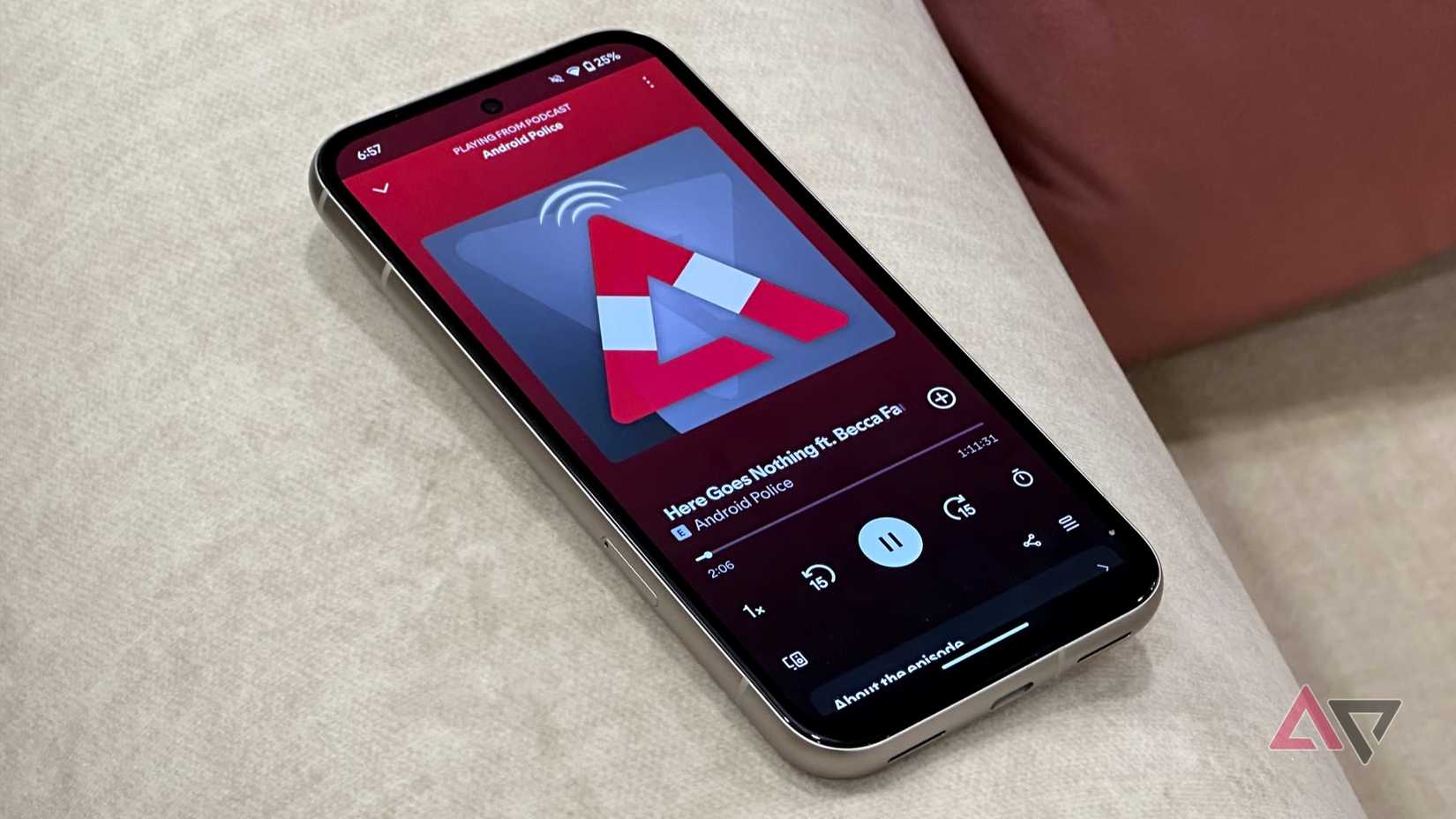 Pixel 8a on a white sofa with Android Police podcast playing on Spotify