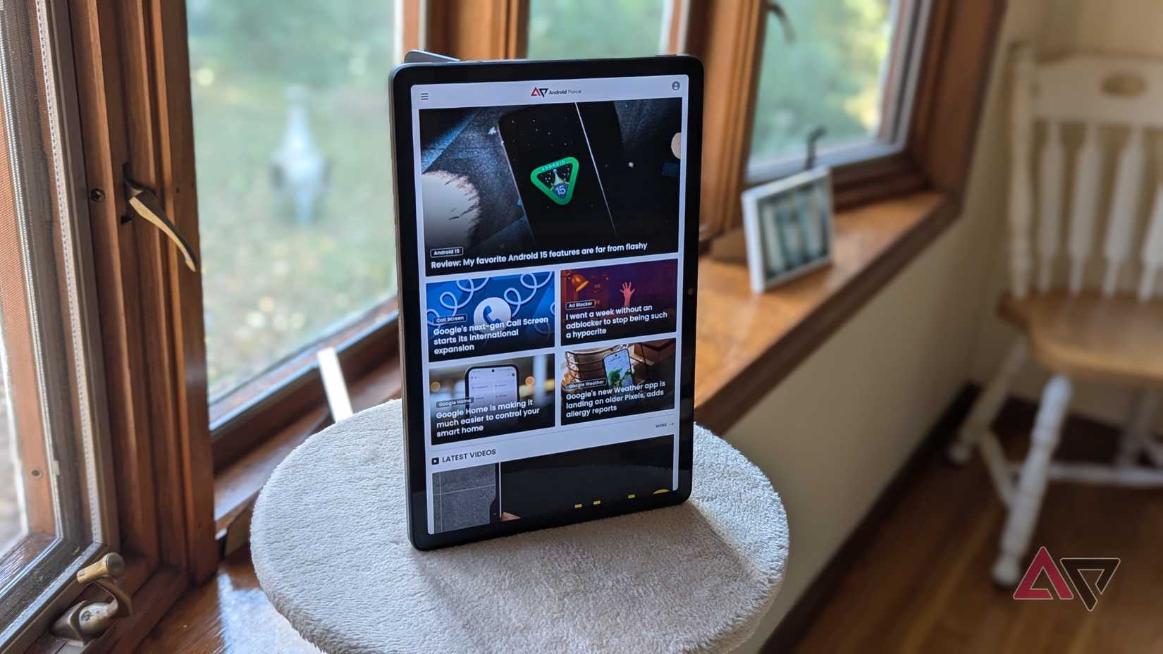 A frente de um Lenovo Chromebook Duet 11 (2024) no modo retrato sentado no topo de uma árvore para gatos em frente a uma janela