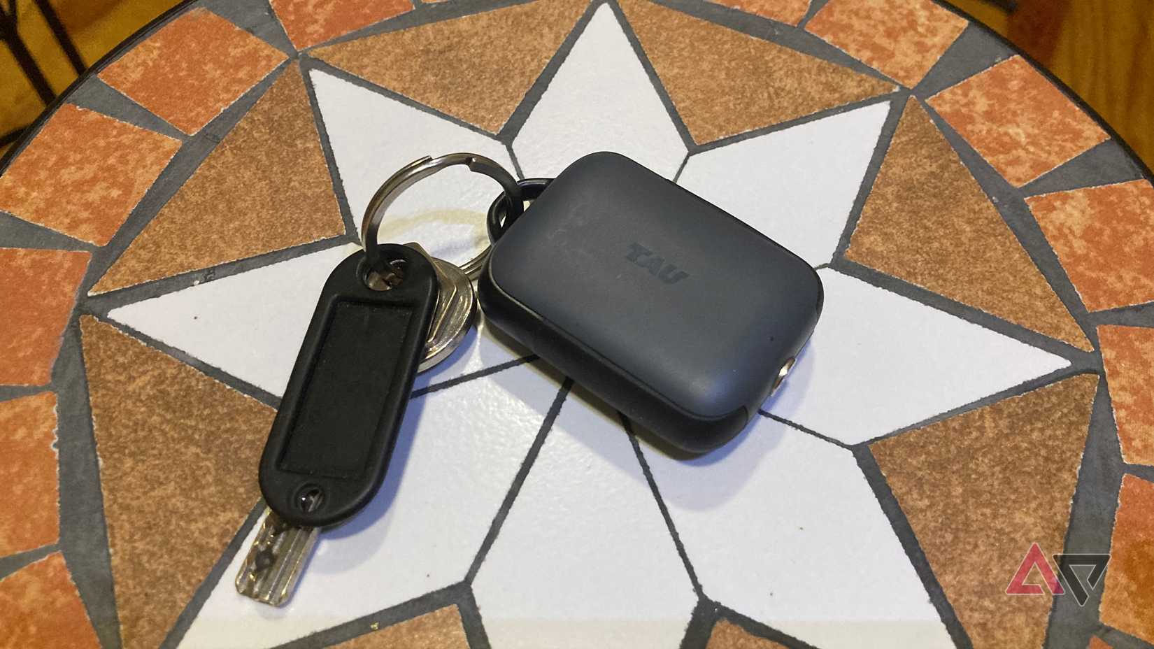 A picture of the Rolling Square Tau 2 power bank on a stone table with keys attached