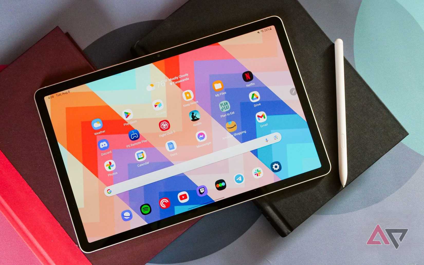 Galaxy Tab S9 adagiato su libri con sfondo colorato, penna a lato