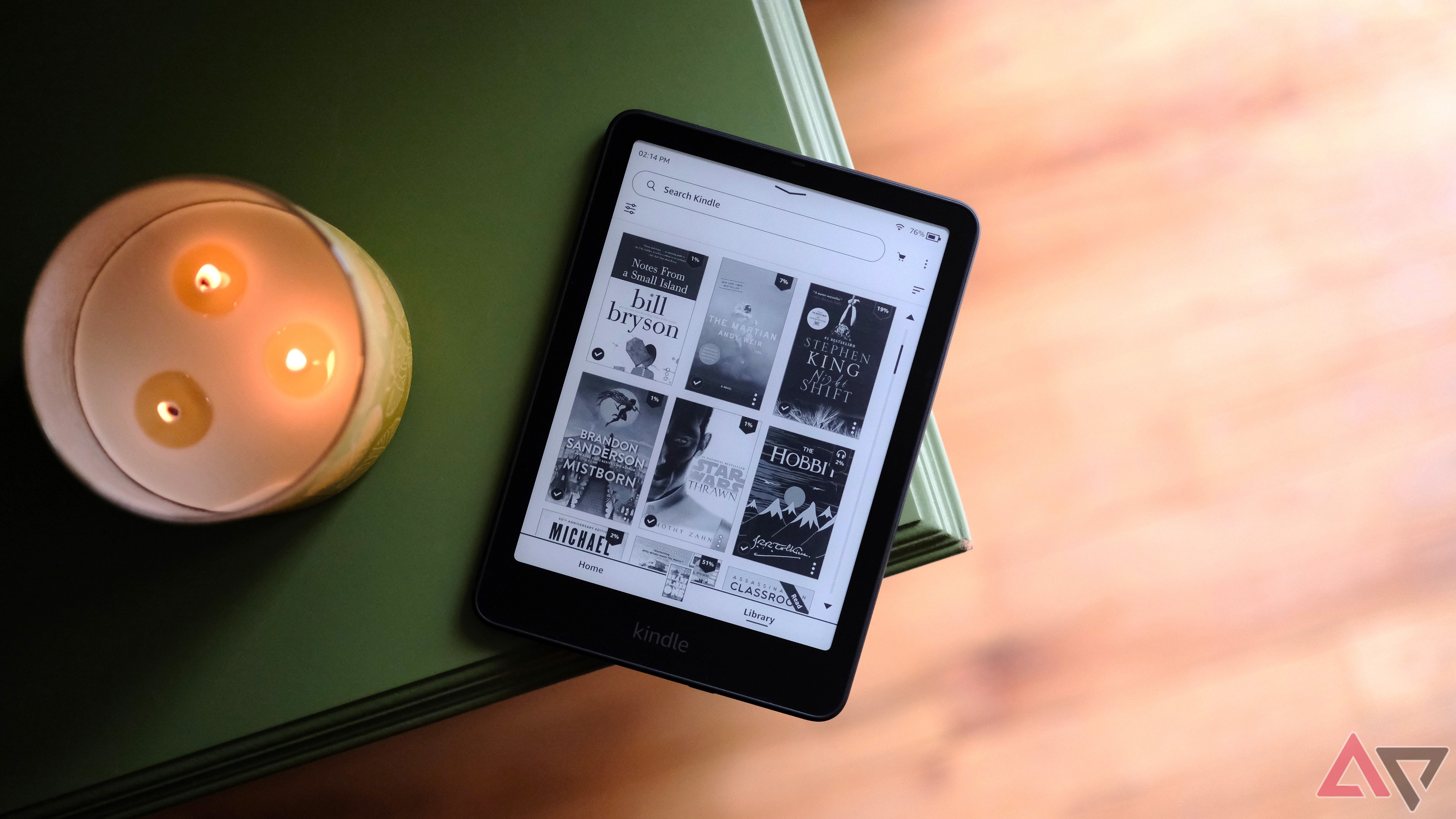 Kindle Paperwhite (2024) appoggiato sul bordo del tavolo che mostra lo schermo con la selezione dei libri