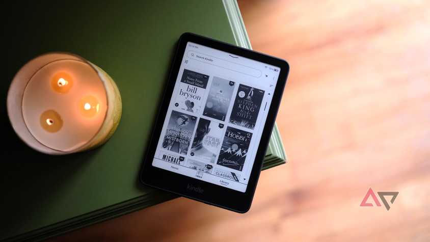 Kindle Paperwhite (2024) put on the edge of the table showing the screen with the book choice
