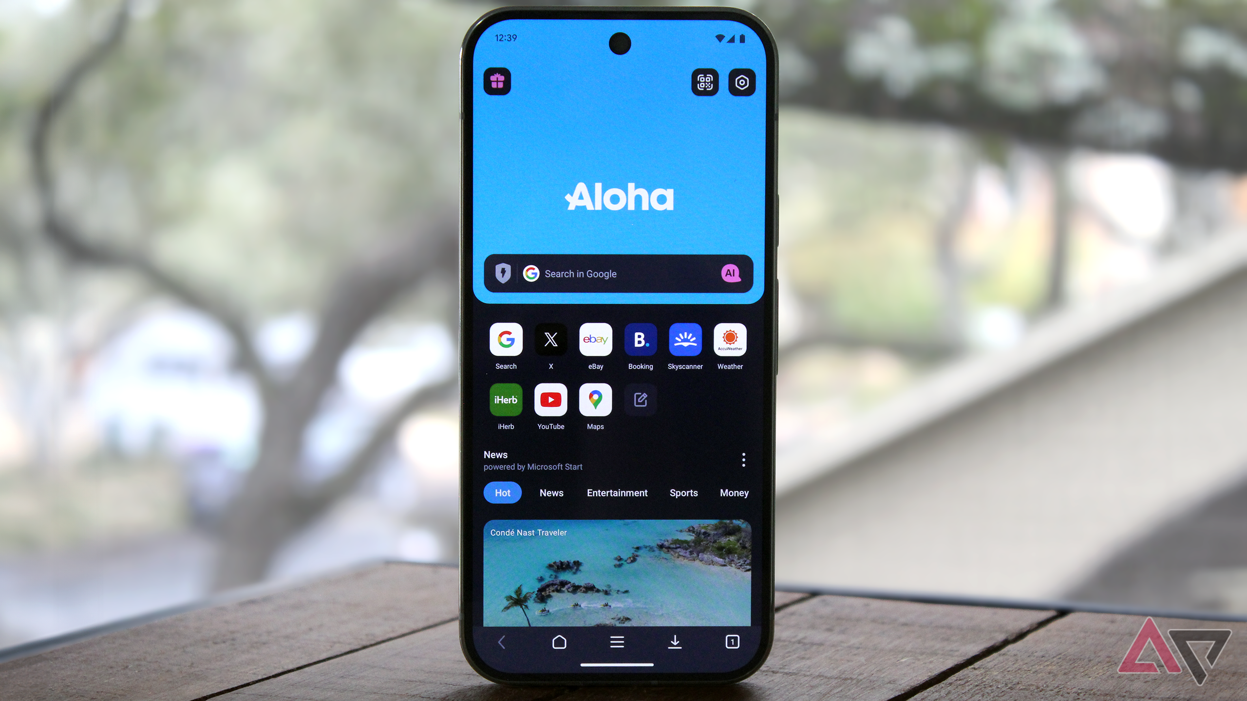 Photo of the Aloha Browser on an Android phone near a window with trees in the background.