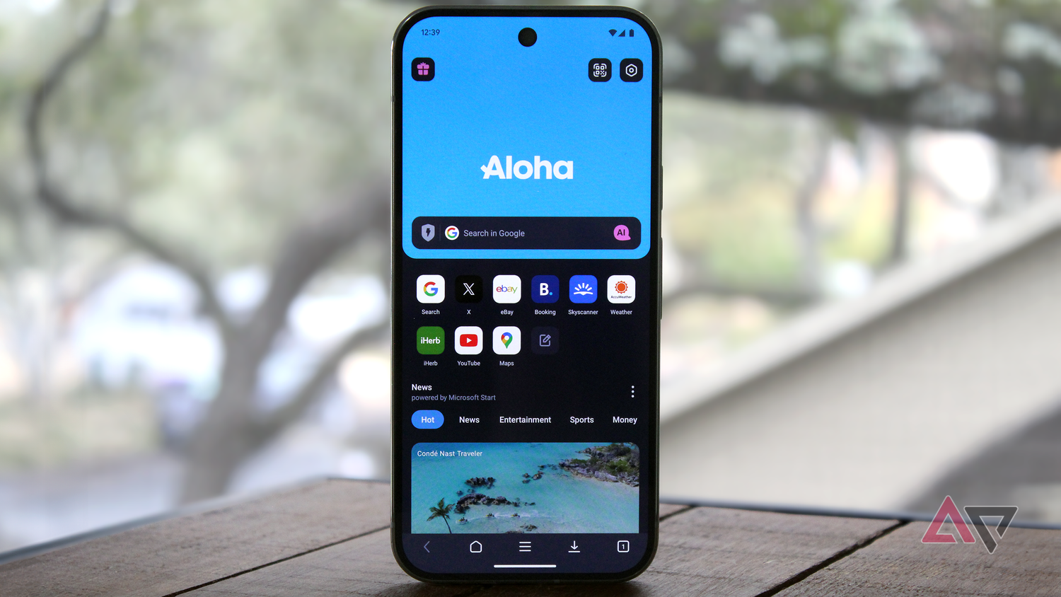 Photo of the Aloha Browser on an Android phone near a window with trees in the background.