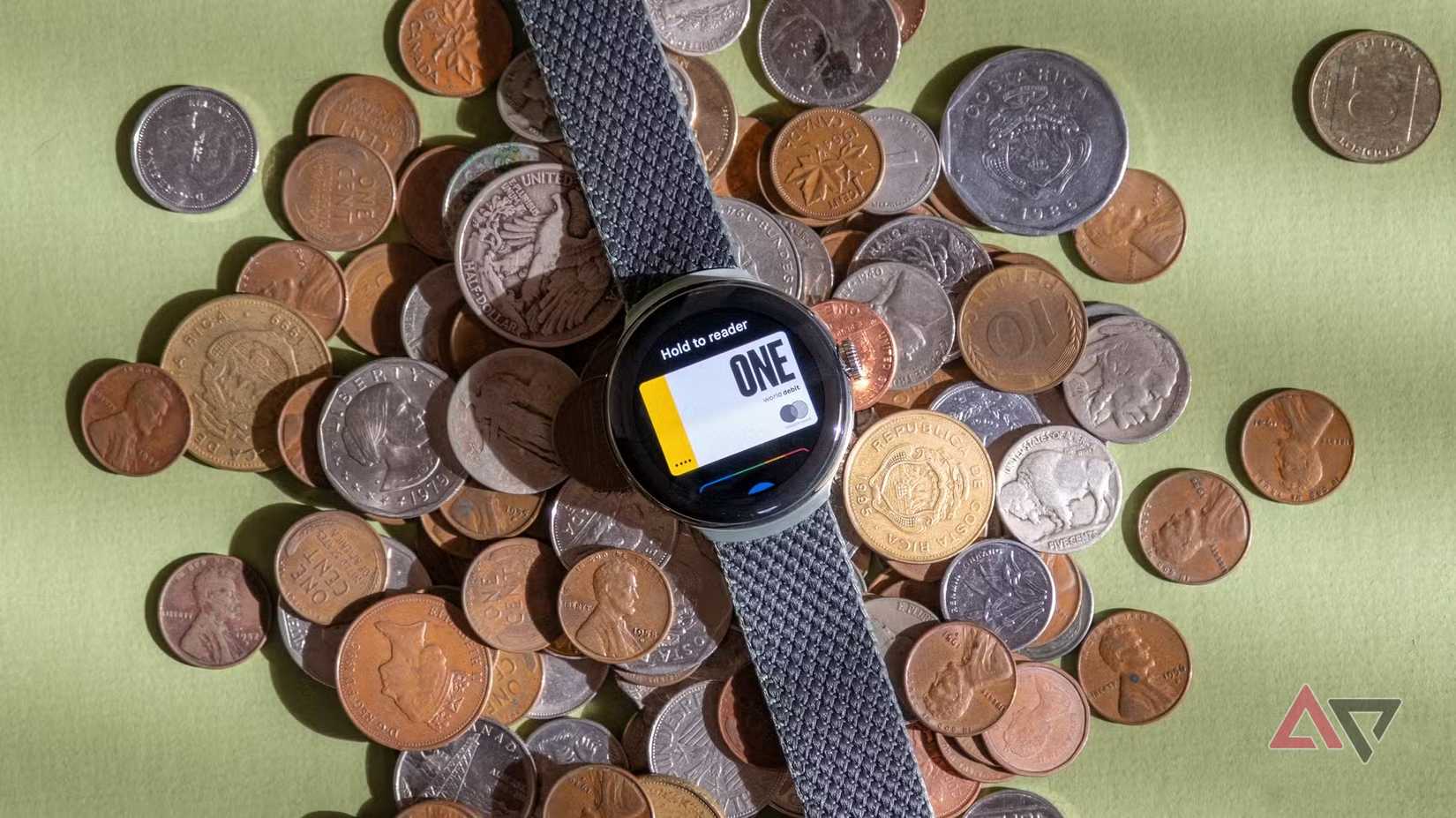 A pixel Watch running Google Wallet. The Watch is resting on a heap of coins on a table.