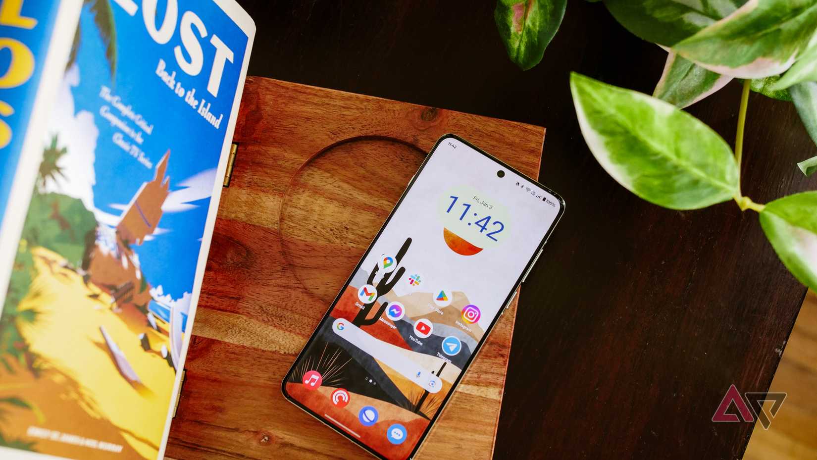 OnePlus 13 على حامل الكتب مع تشغيل الشاشة.
