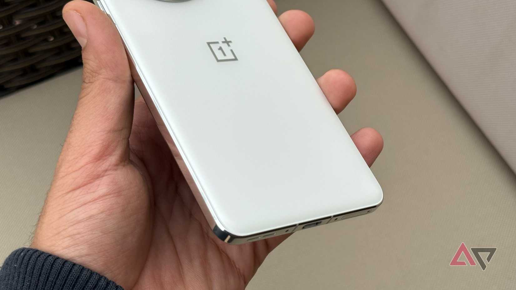 Close-up of OnePlus 13’s sleek white back in hand