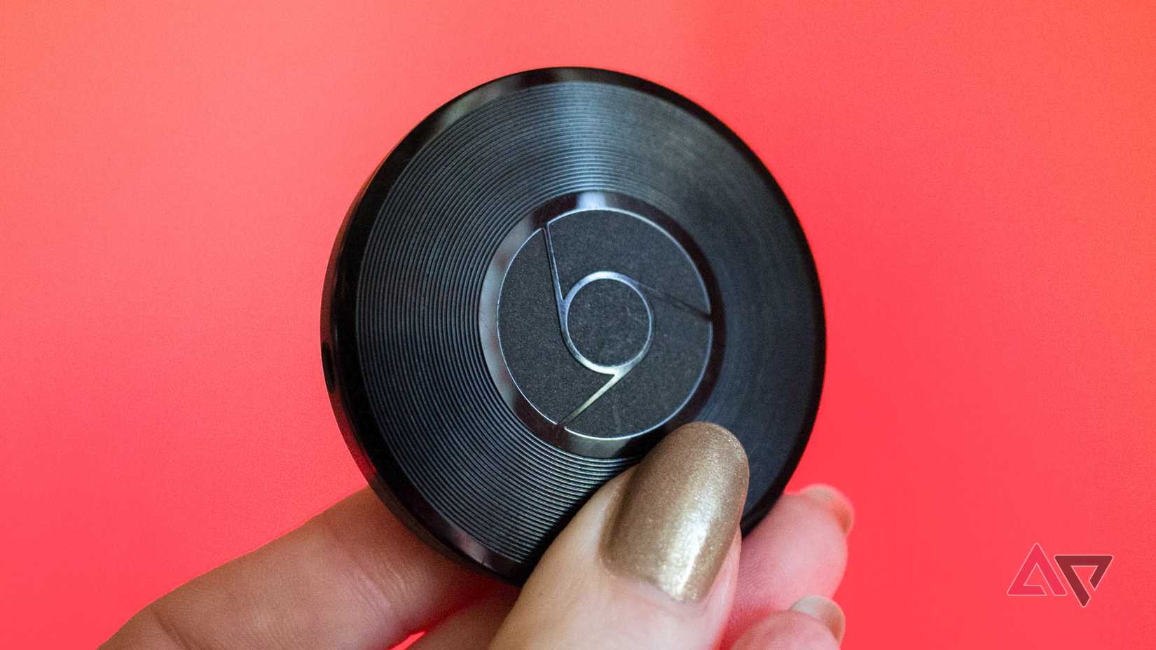 A hand holding the Chromecast Audio.