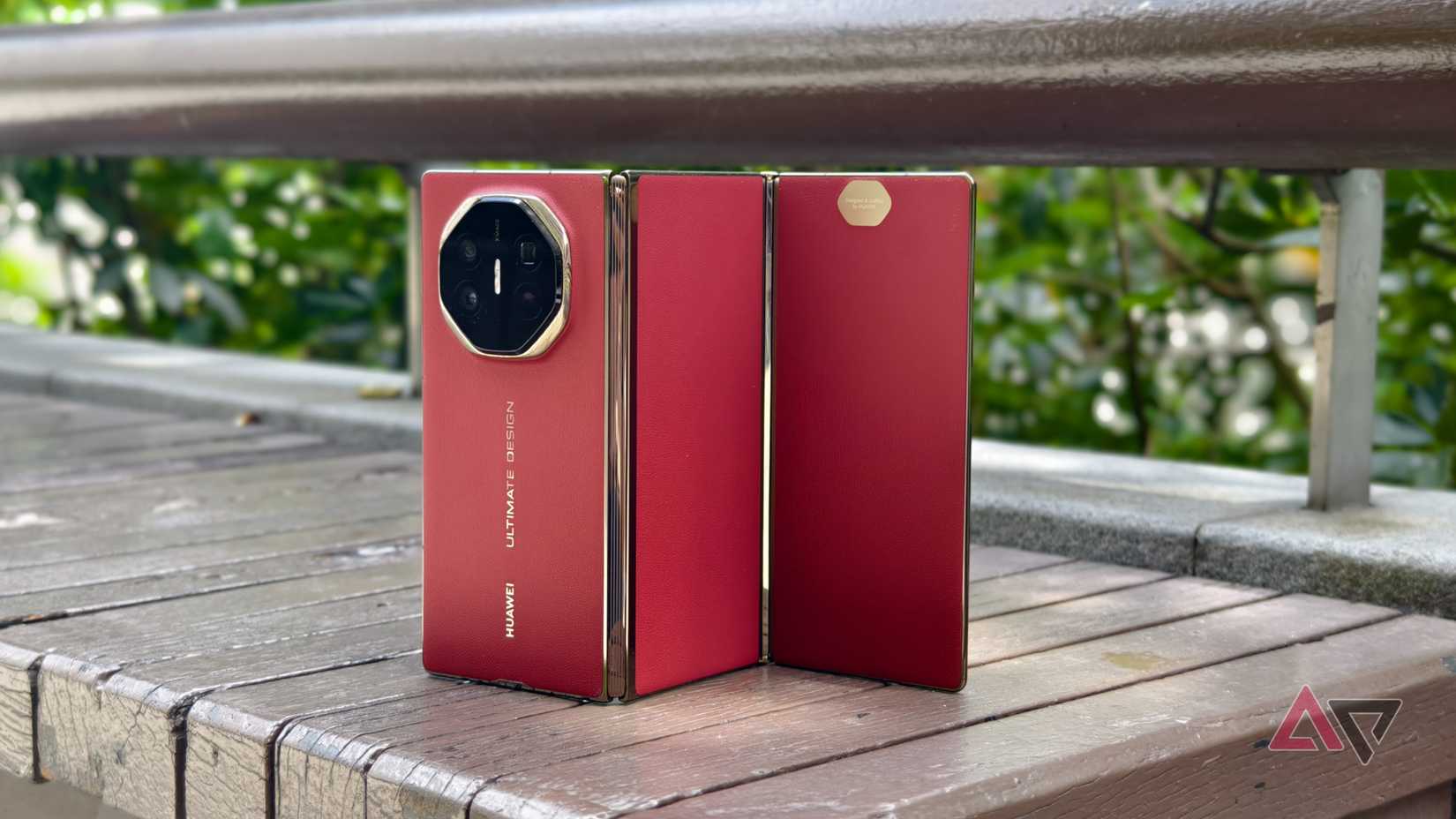 Huawei Mate XT trifold phone on a park bench