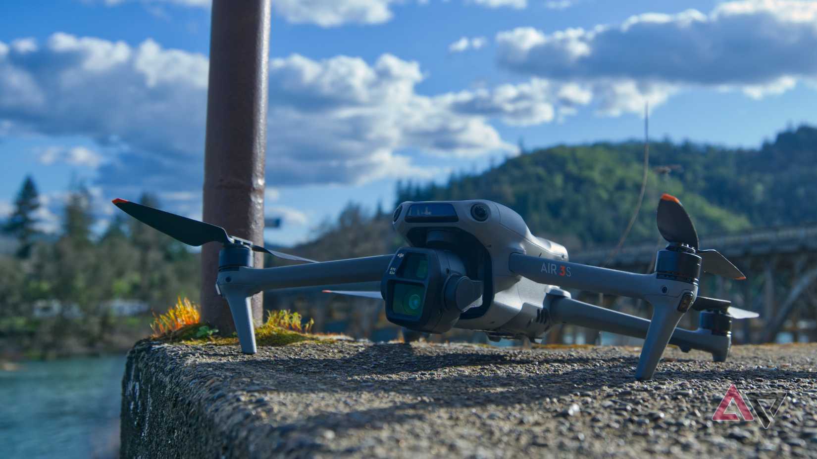 A shot top of the Air 3s DJI with a river, mountain and pulling in the background