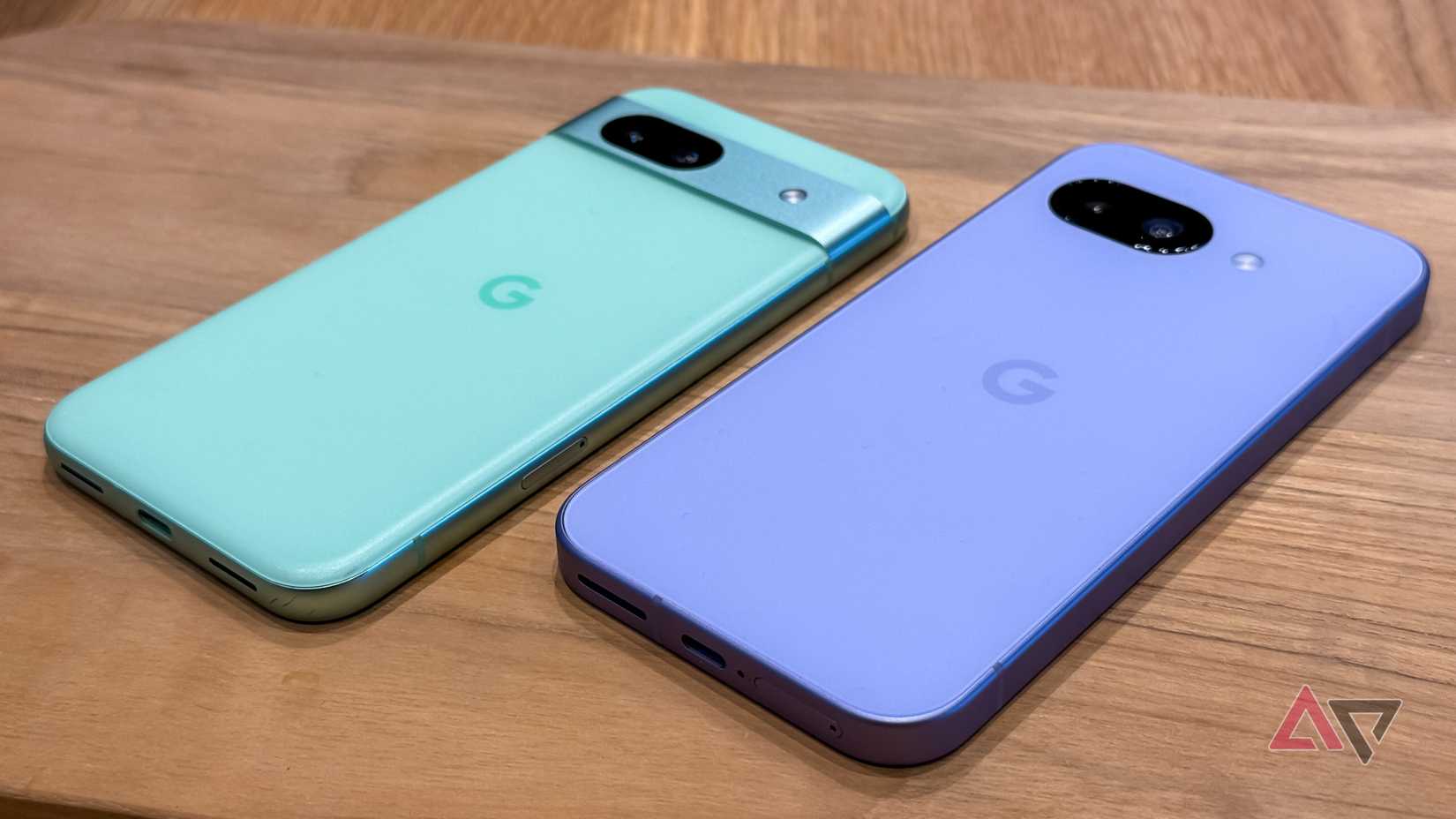 The Pixel 9a next to the Pixel 8a face down on a table.