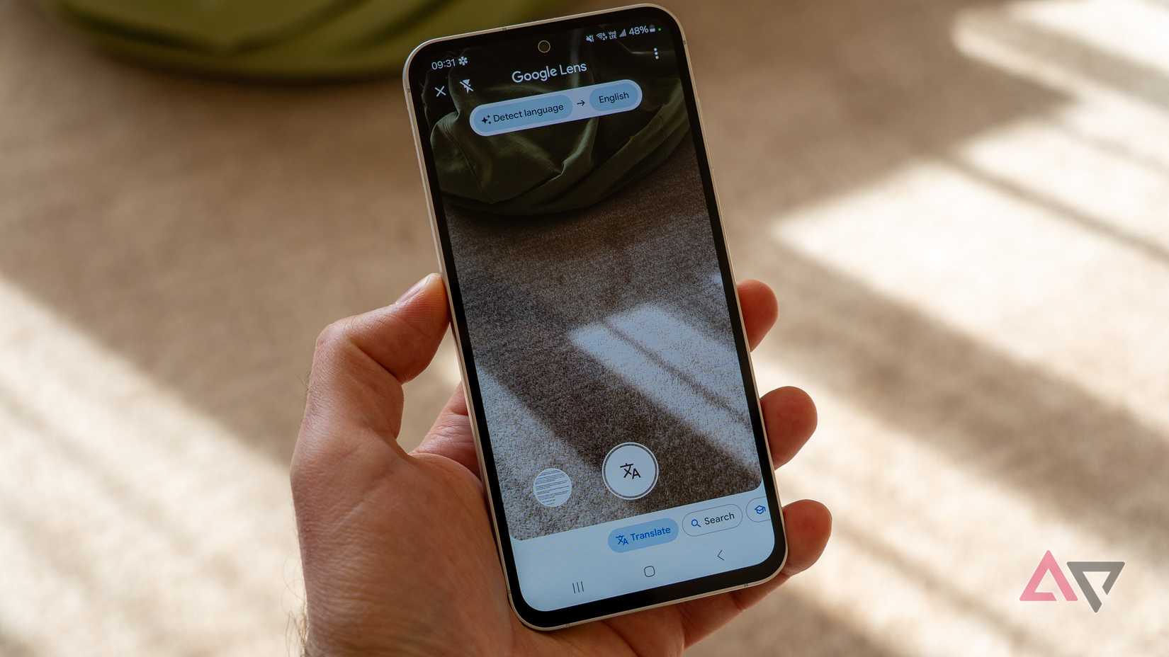 um telefone na mão exibindo o Google Tradutor com recurso de câmera