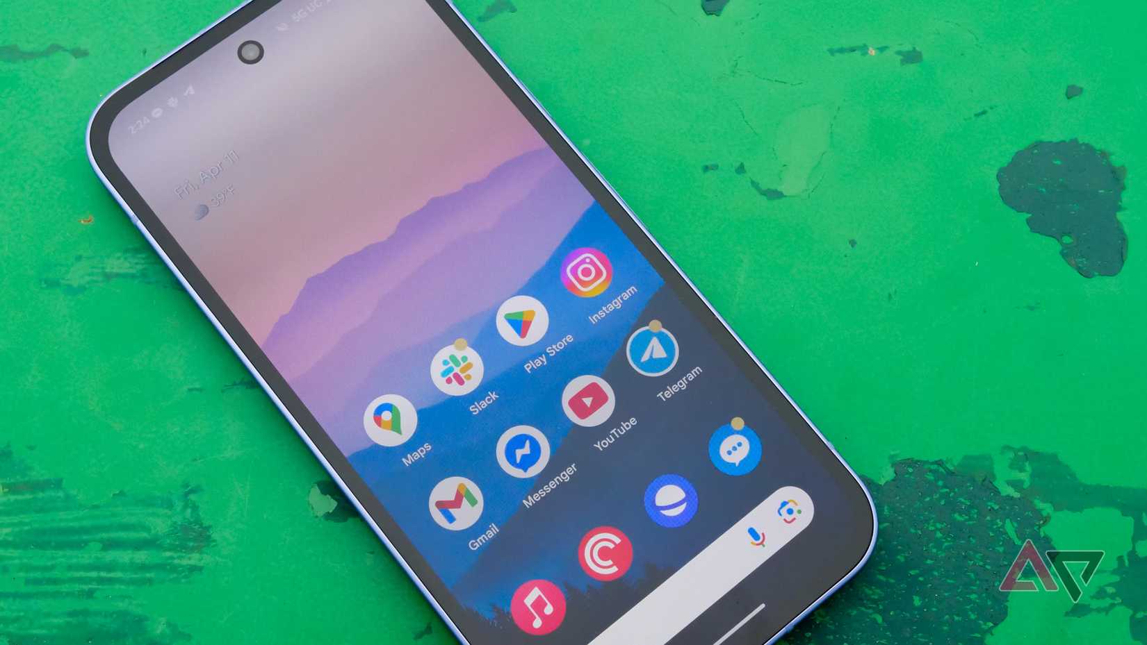 لا يحتاج Google Pixel 10a إلى أن يكون Tensor G5 مميزًا 2 هاتف Google Pixel 9a على طاولة خضراء في حديقة بالخارج، مع شاشة عرض متجهة للأعلى