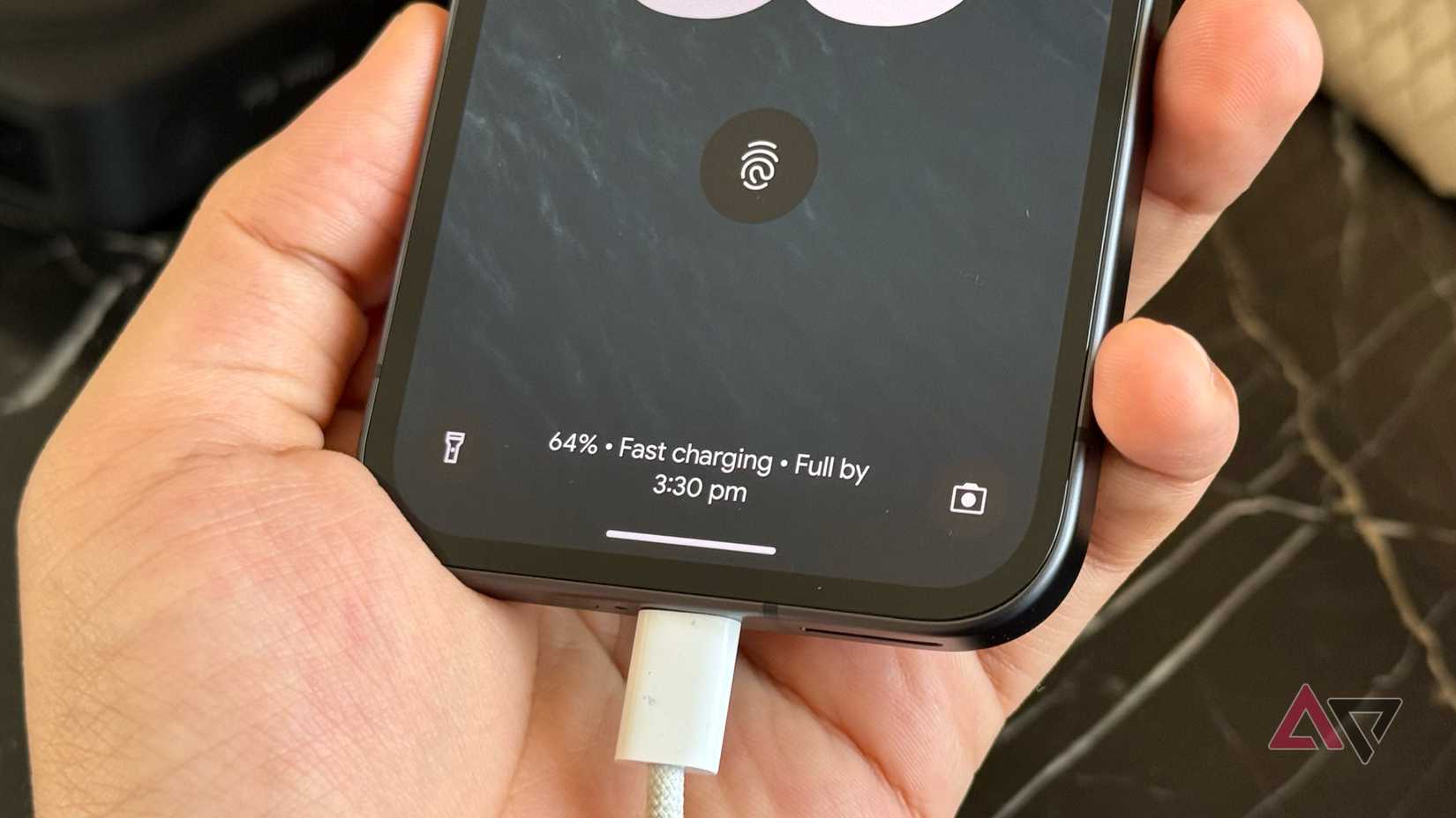 Pixel 9a carregando por meio de um cabo USB-C mostrando porcentagem na tela de bloqueio