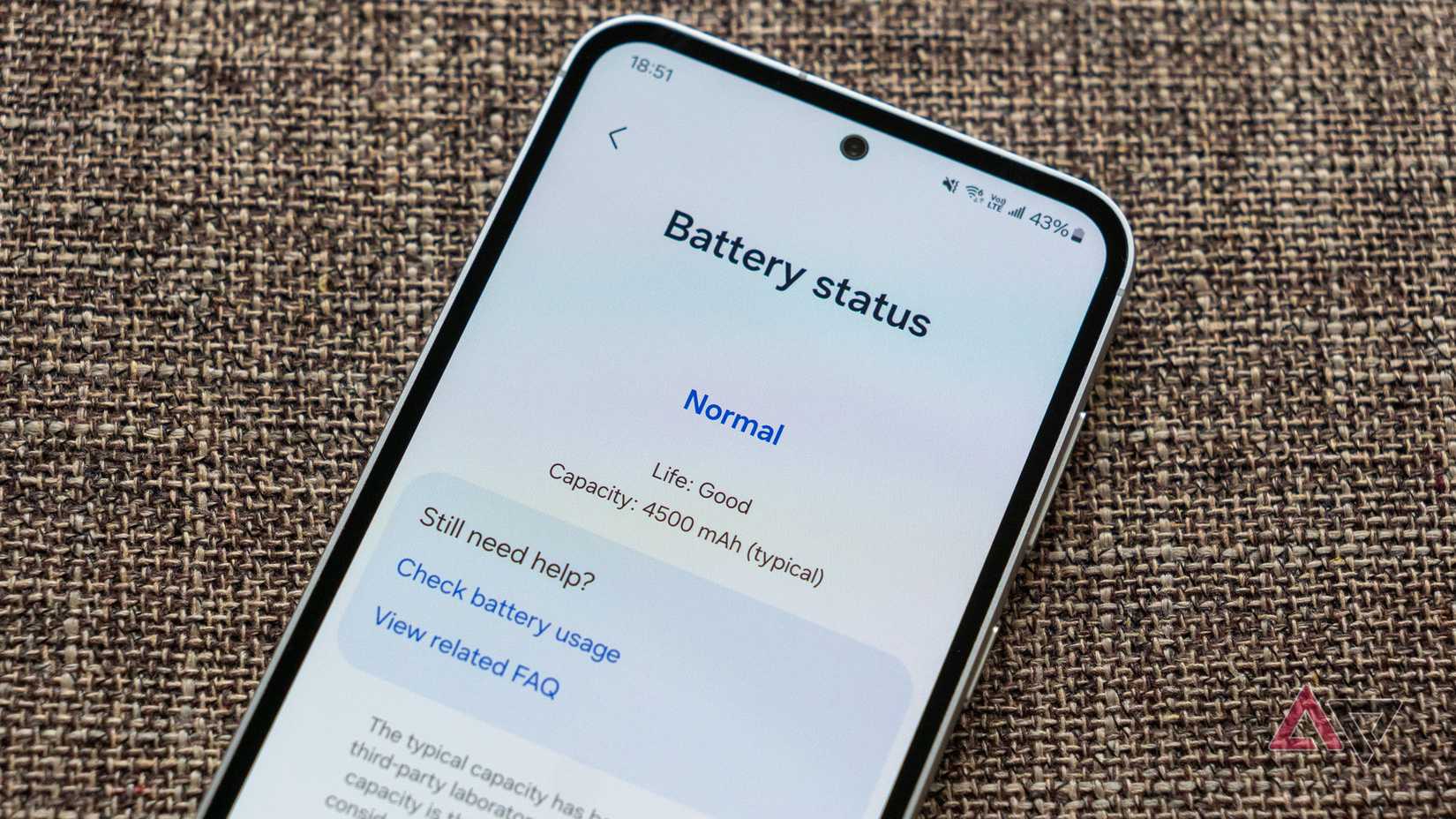 um telefone em uma superfície de tecido exibindo a tela de informações de integridade da bateria no aplicativo Samsung Members