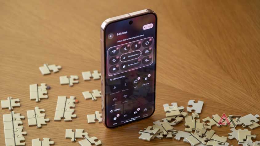 A Pixel 9 Pro open to quick settings, sitting upright among puzzle pieces.