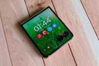 The Moto Razr Ultra with its cover display showing on a wooden backdrop.