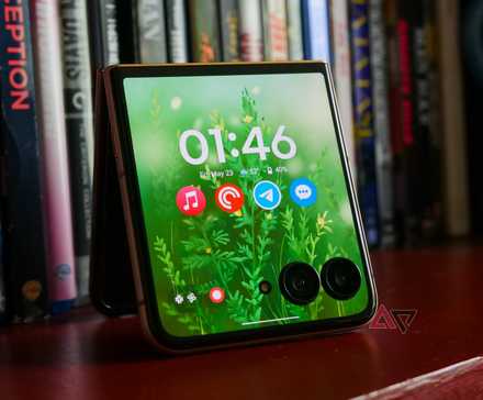 The Moto Razr Ultra with its cover display on resting on a bookcase.