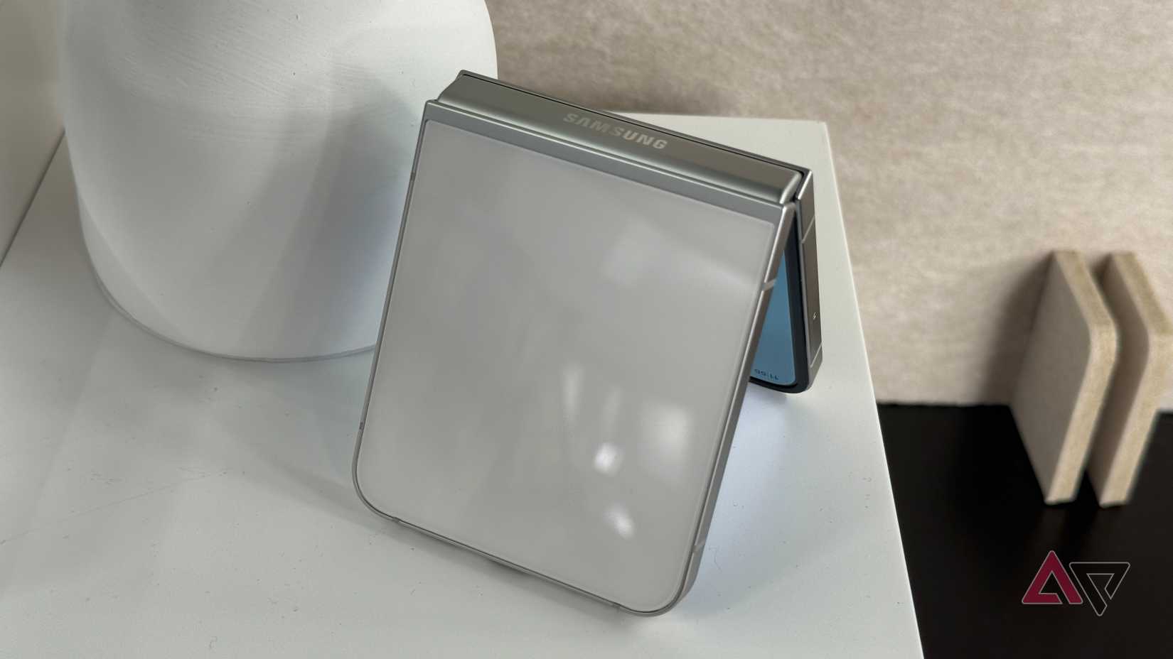 Samsung Galaxy Z Flip 7 FE in white on a tablet next to a lamp