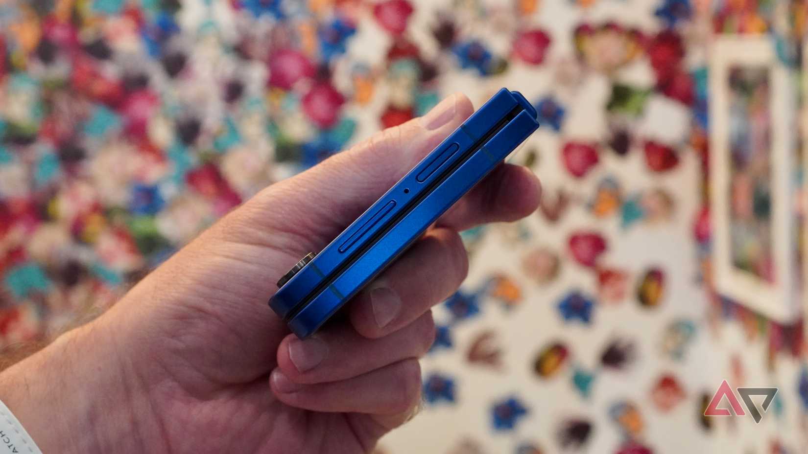 Uma pessoa segurando o Samsung Galaxy Z Flip 7 fechado, mostrando os botões