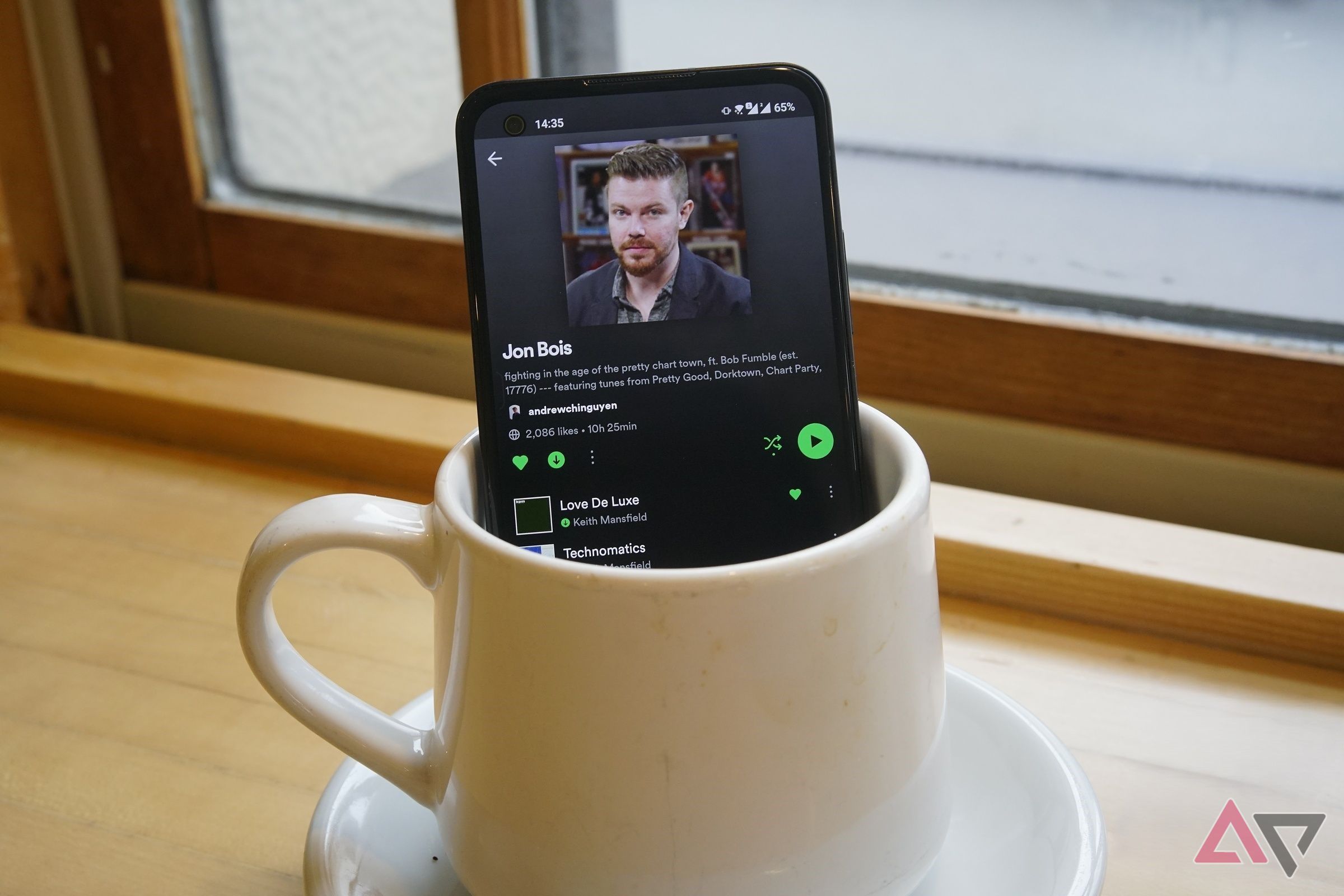 Spotify sullo schermo di un telefono che sta bruciando in una tazza di caffè
