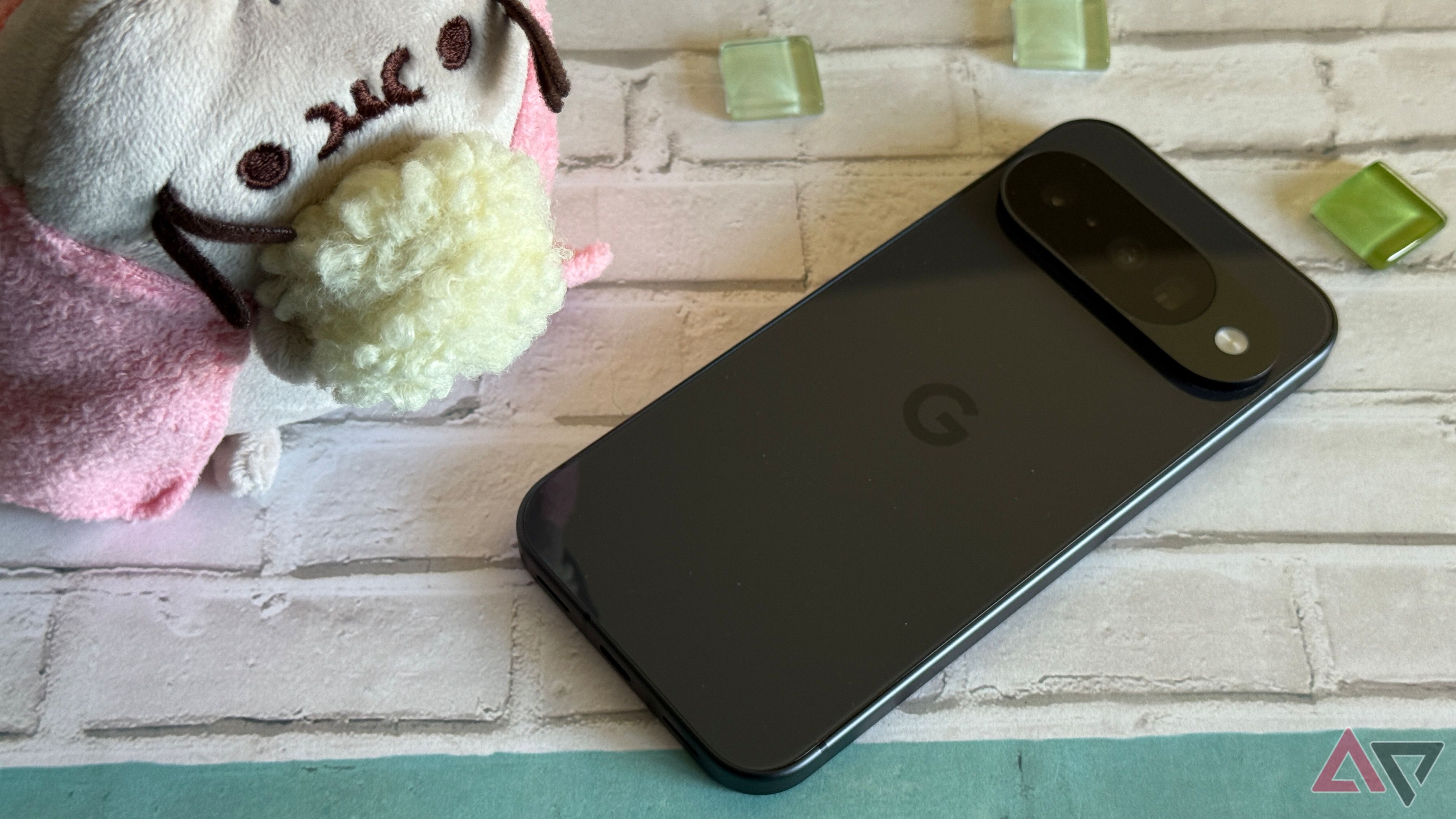 Google Pixel 10 laying next to a Pusheen