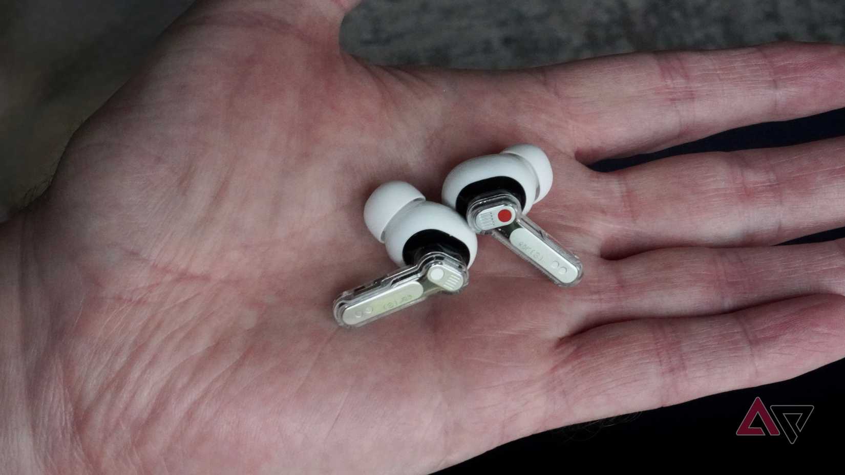 A person holding the Nothing Ear 3 earbuds