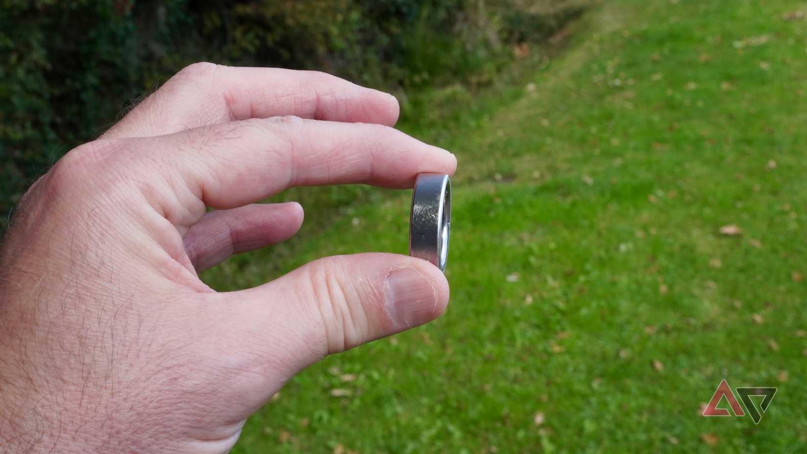 A person holding the Oura Ring 4 showing scratches